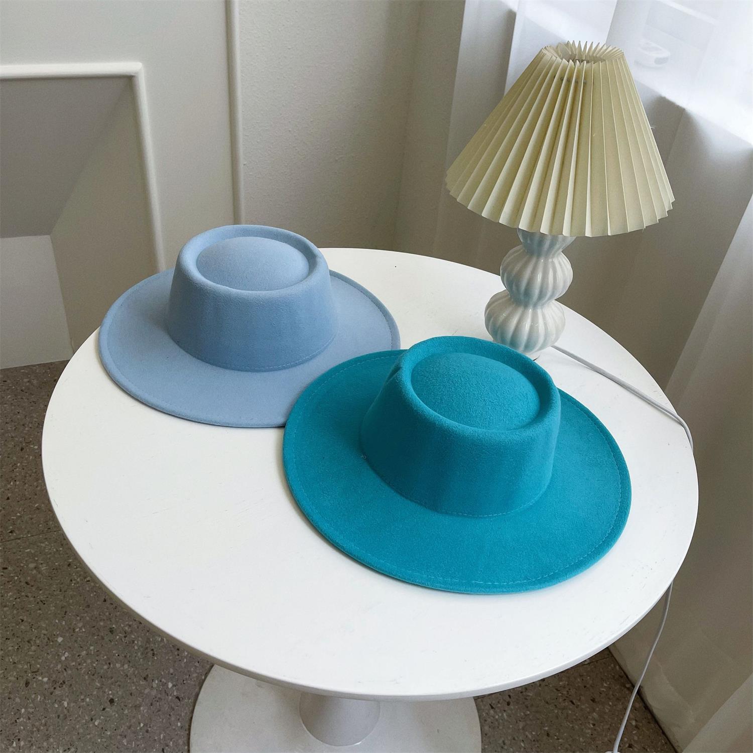 Leo lamp behind blue hats on a white table