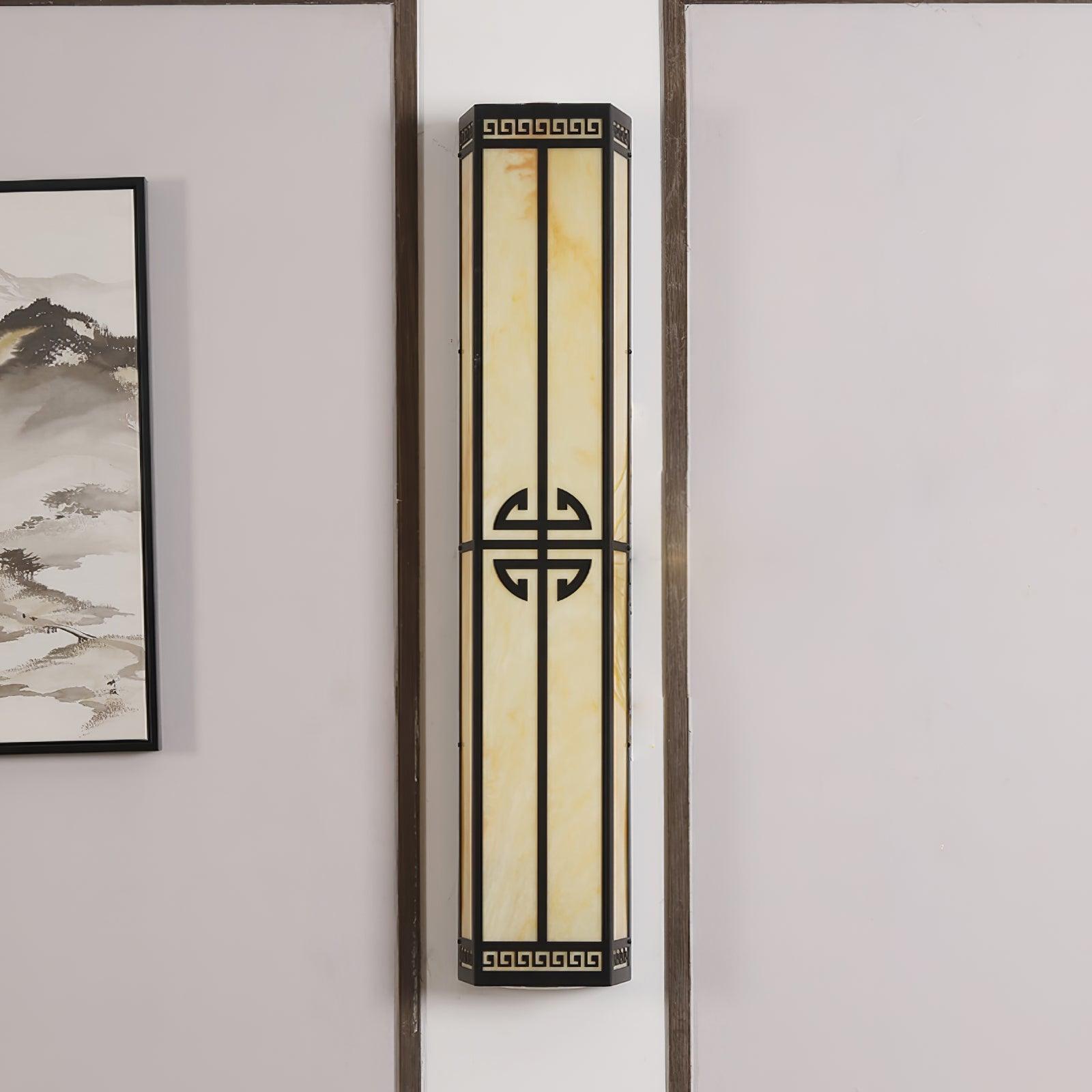 Unlit After Hours wall light showing cream veining and black frame beside wall molding and artwork