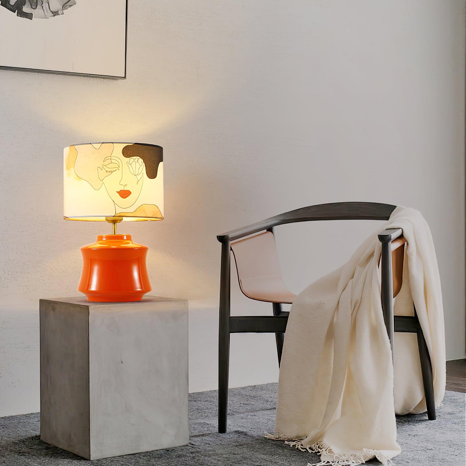 Marilyn lamp on a stone cube table beside a dark chair