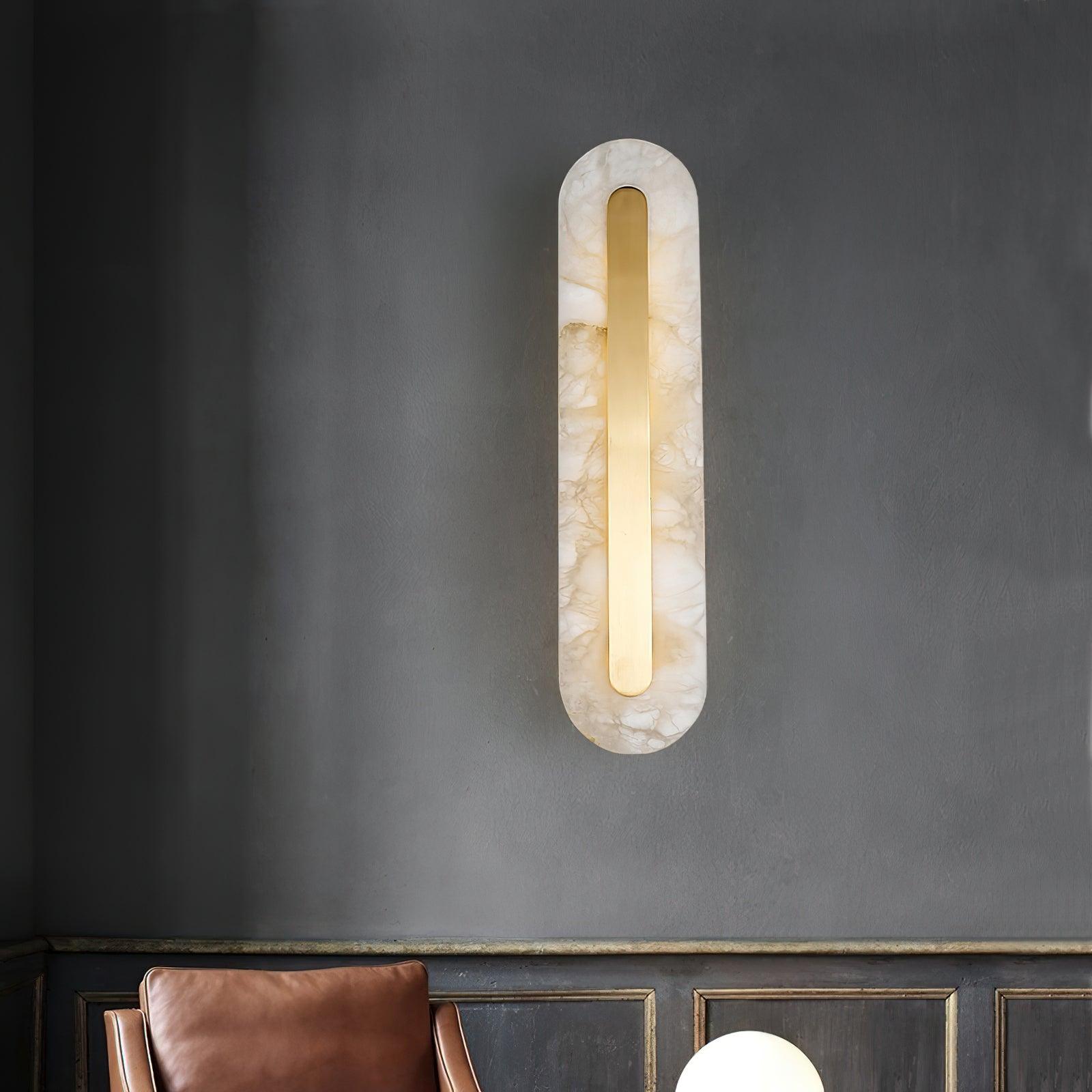 Veined stone wall light above a brown chair and dark wall panelling