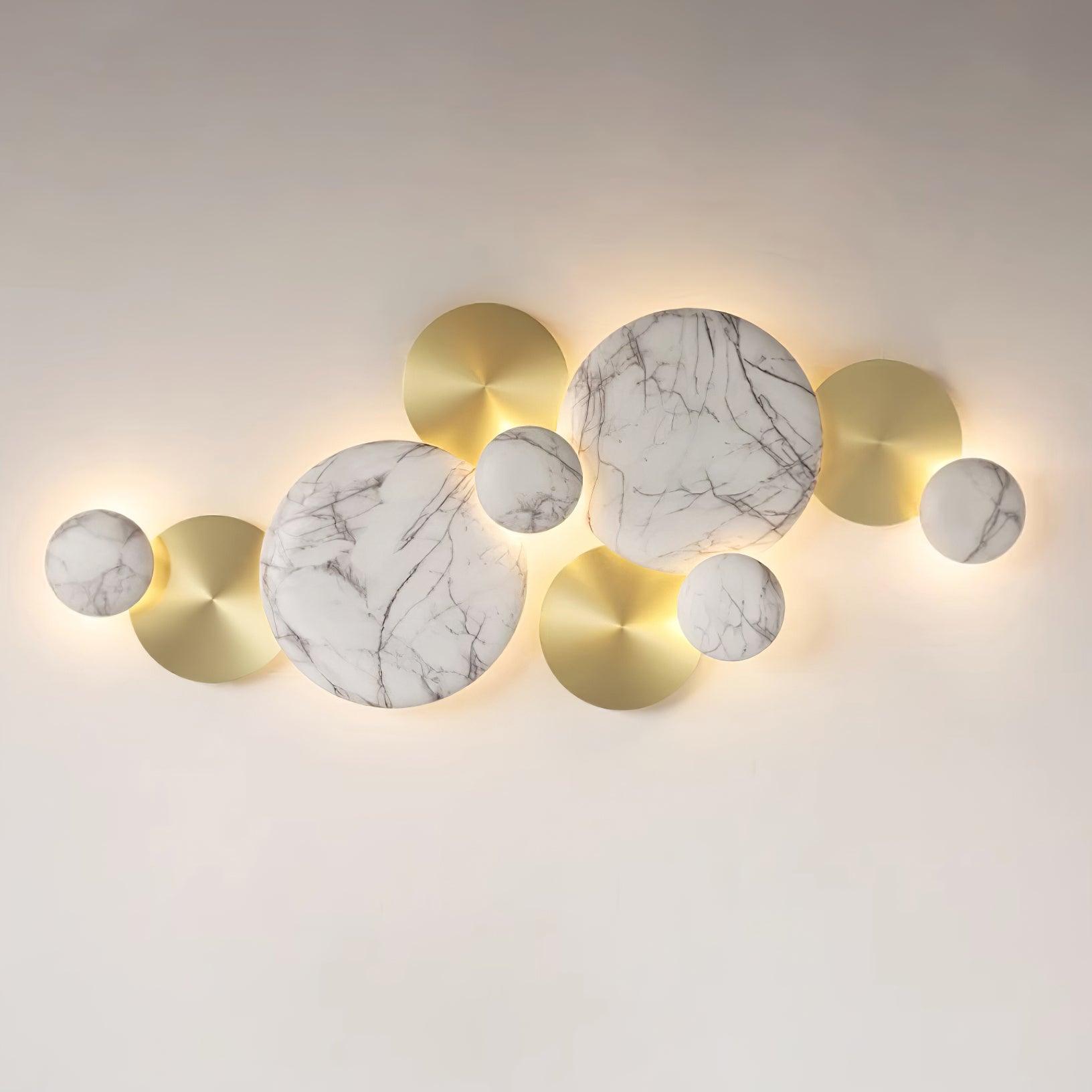 Close front view of the glowing Gold & Marbling lamp with white veined faces and gold-tone discs