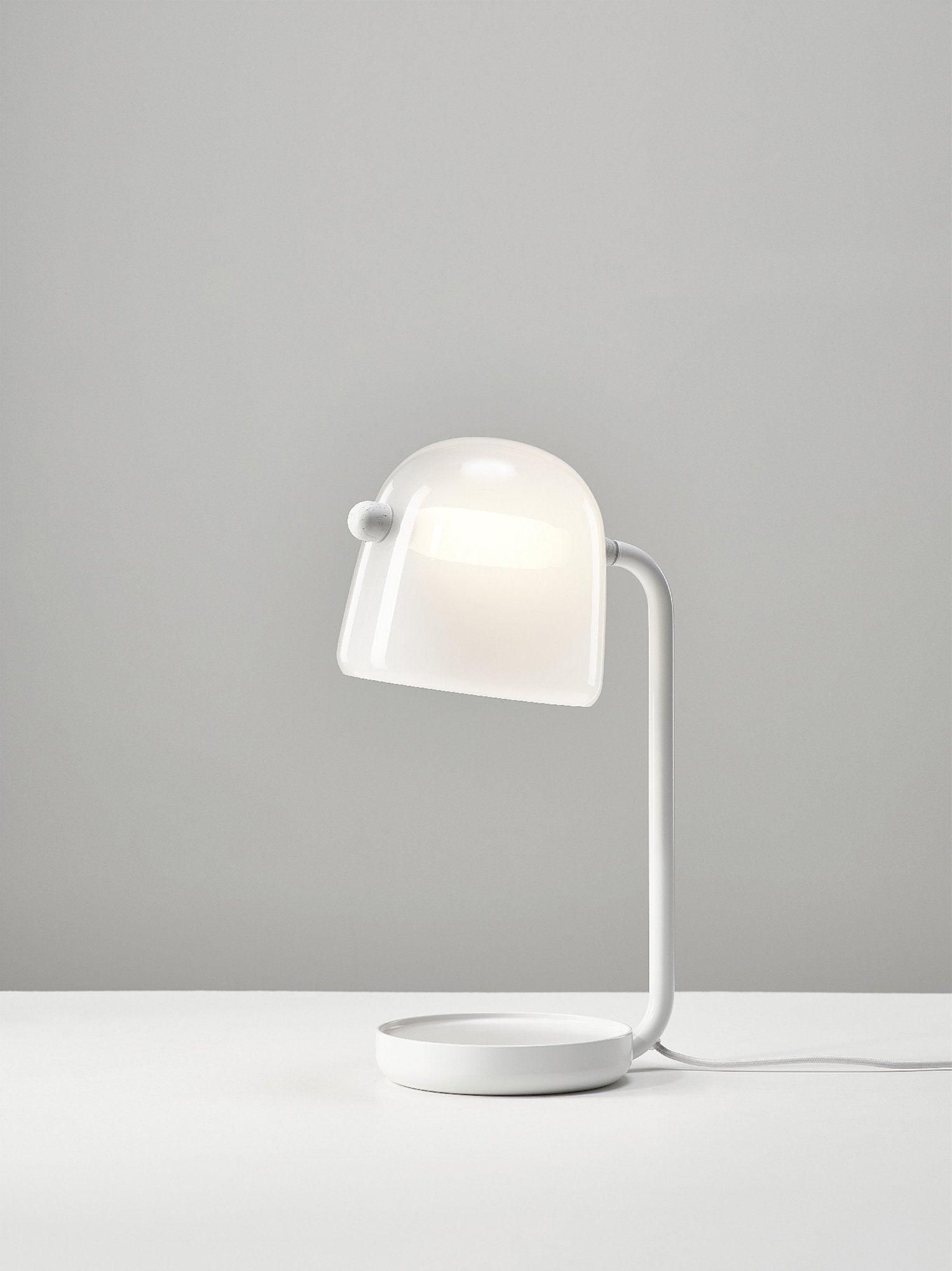 White Mona lamp illuminated on a pale surface