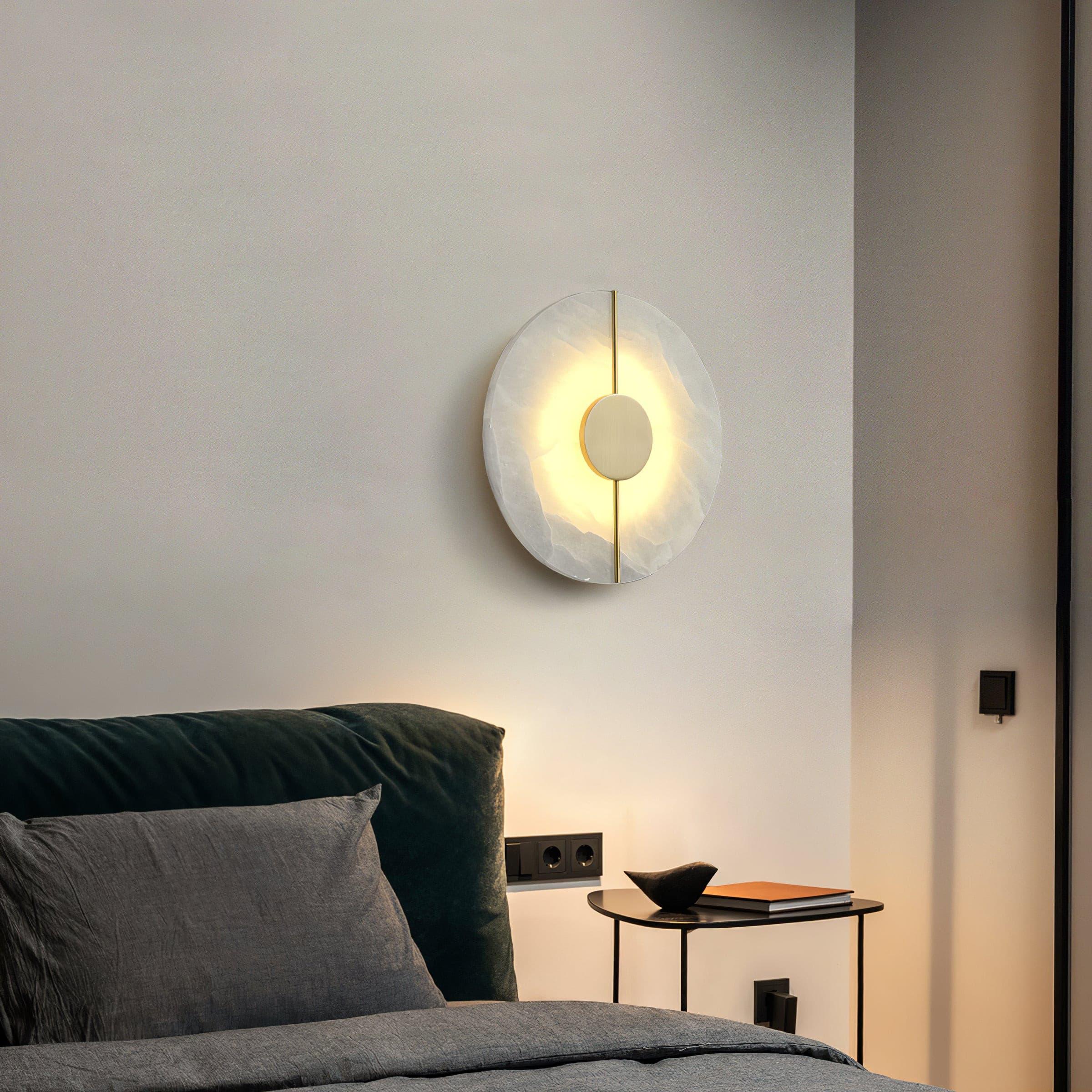 Round wall light beside a dark green sofa