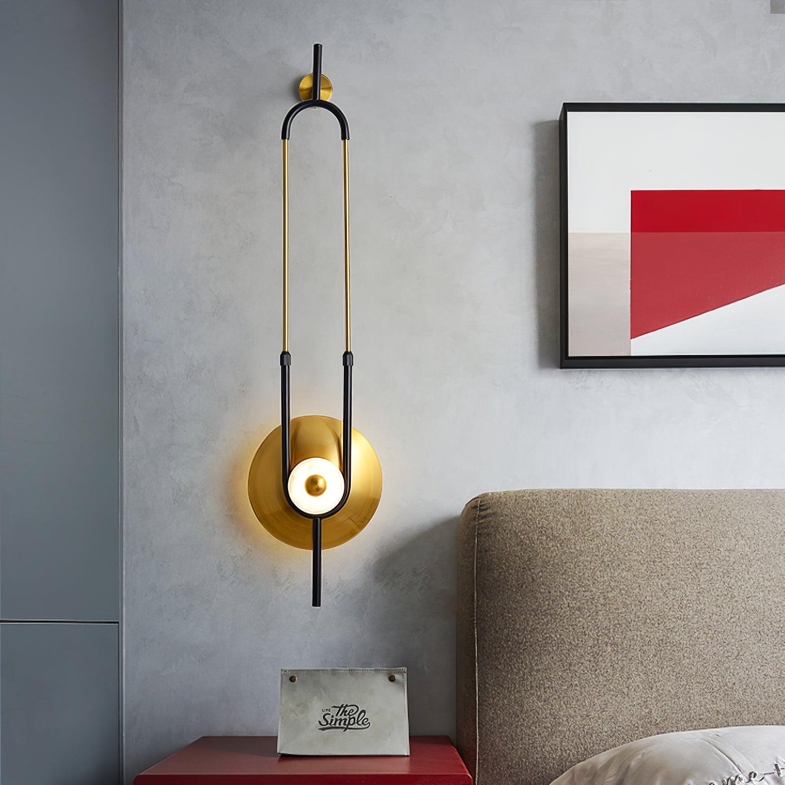 Ellipse Ring wall light beside beige headboard, red bedside cabinet and framed red geometric print on grey wall