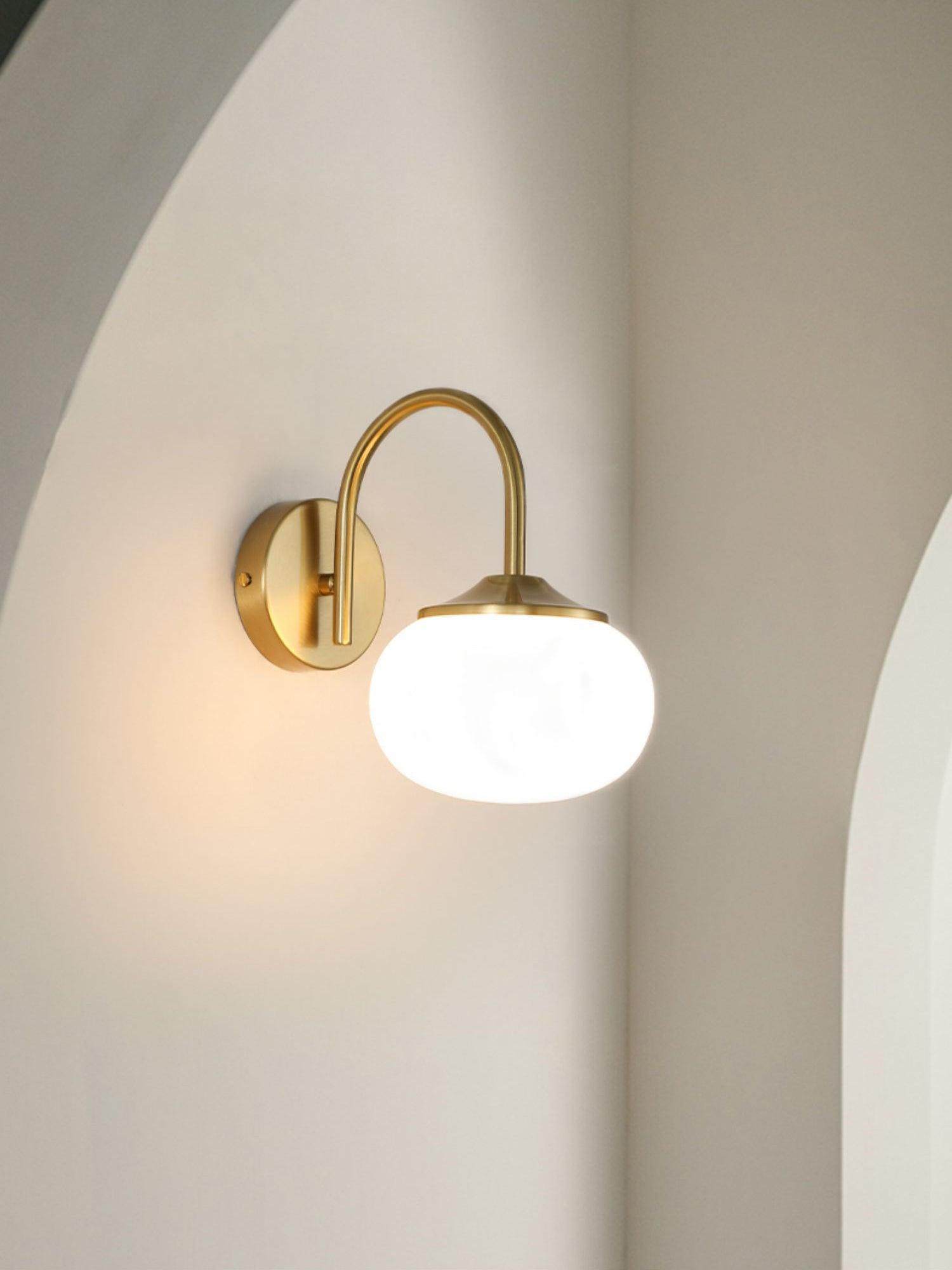 White glowing glass wall lamp within an arched recess