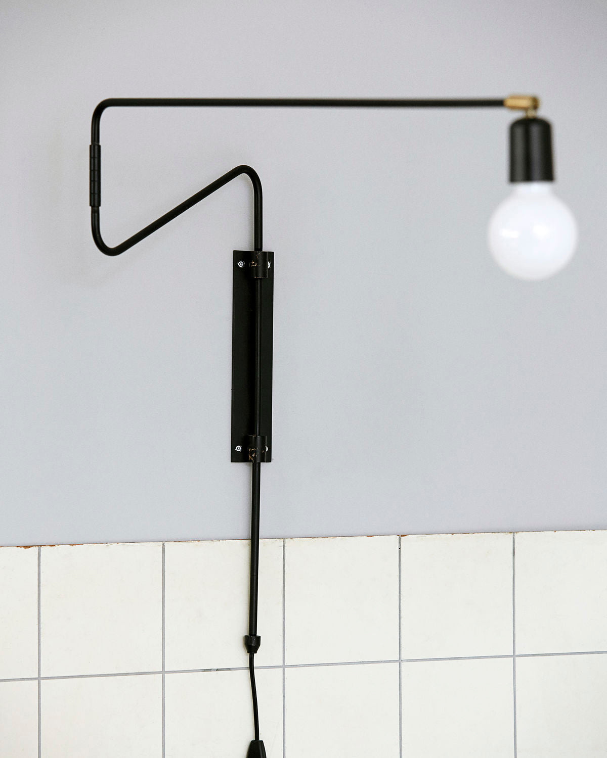 Black Swing fixture and glowing globe bulb