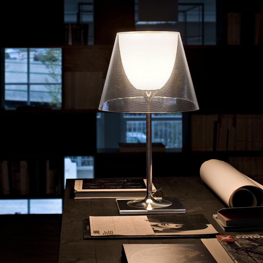 Chrome Prism clear-shade lamp on a desk near a window