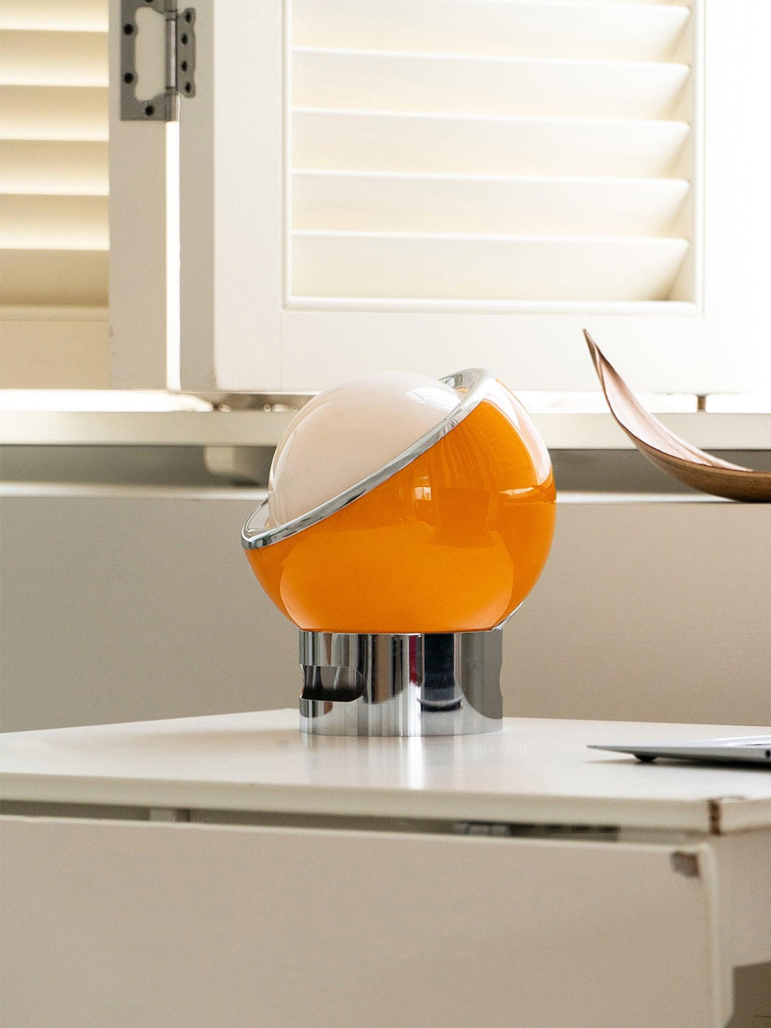 Side view of an orange-toned Valeria lamp on a desk