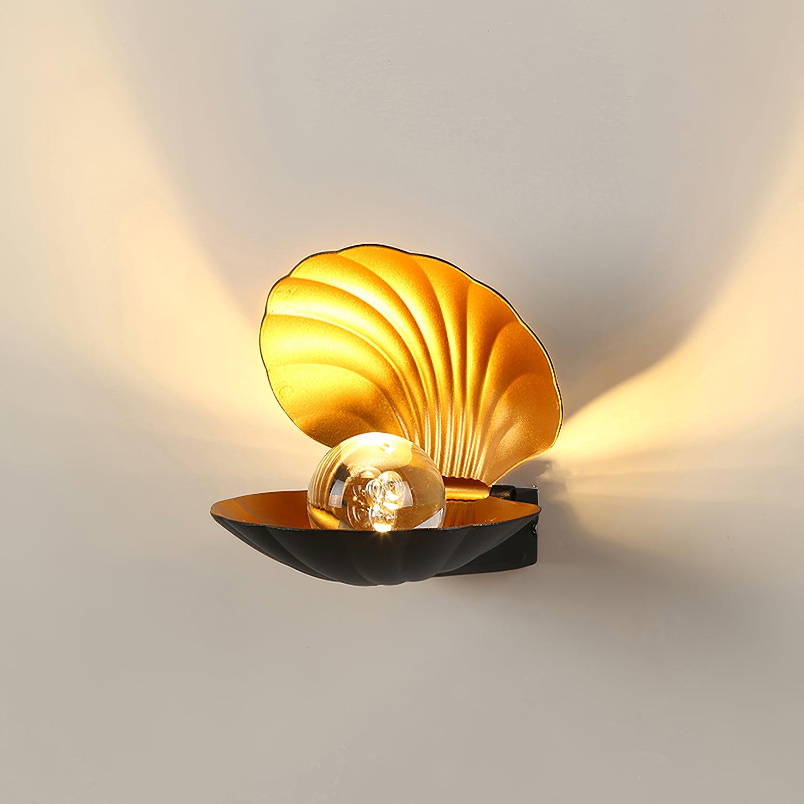 Black Pearl Clam wall light with a glowing clear globe and gold-tone ribbed upper shell