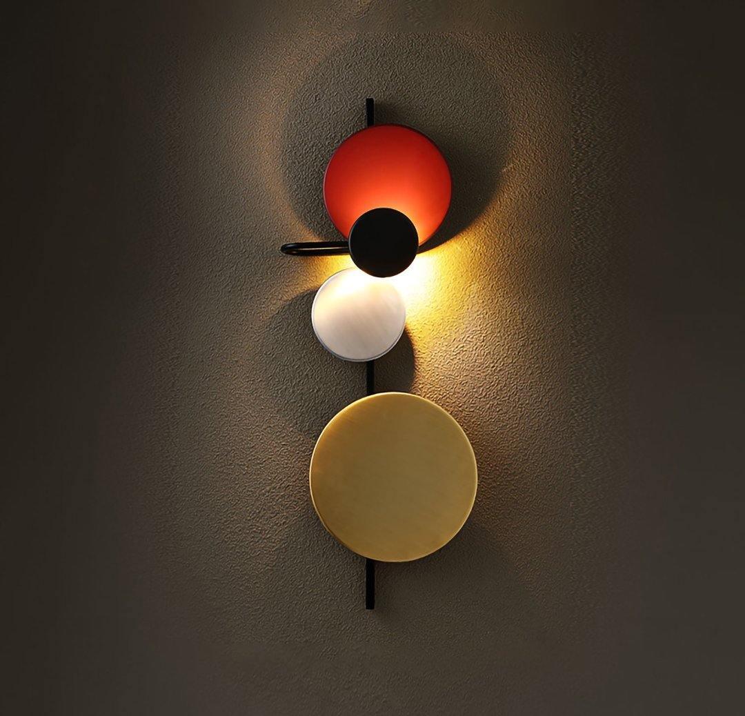 Red disc fixture with glowing reflections on a dark wall