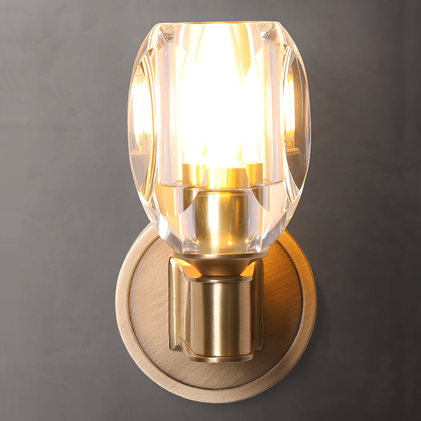 Front view of glowing faceted crystal wall sconce