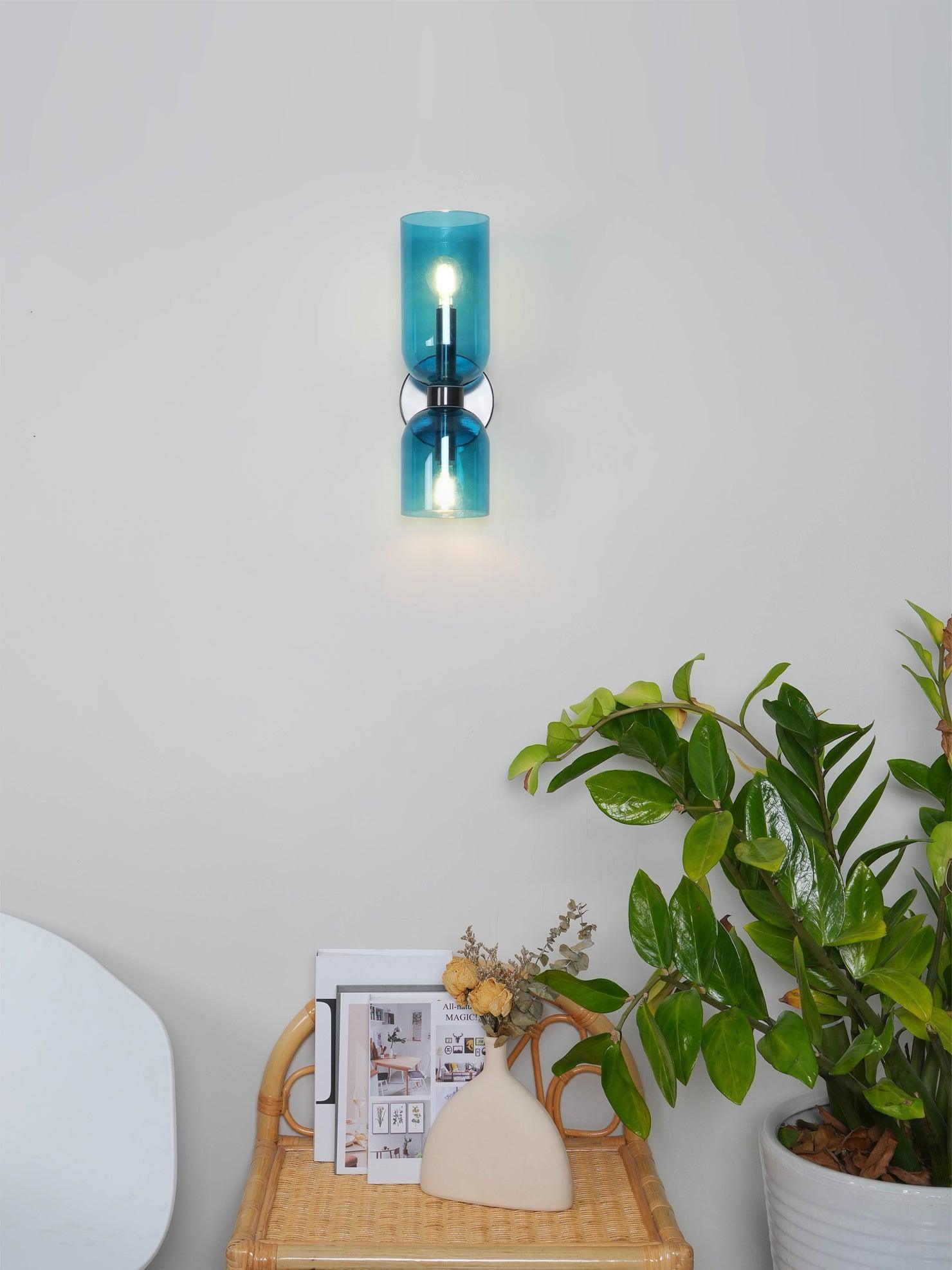 Blue glass Edie wall light above indoor plants