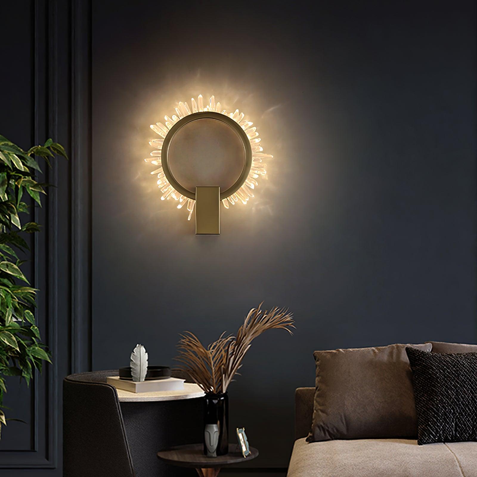 Front crystal sunburst wall light on a dark blue wall above books beside a tan seat