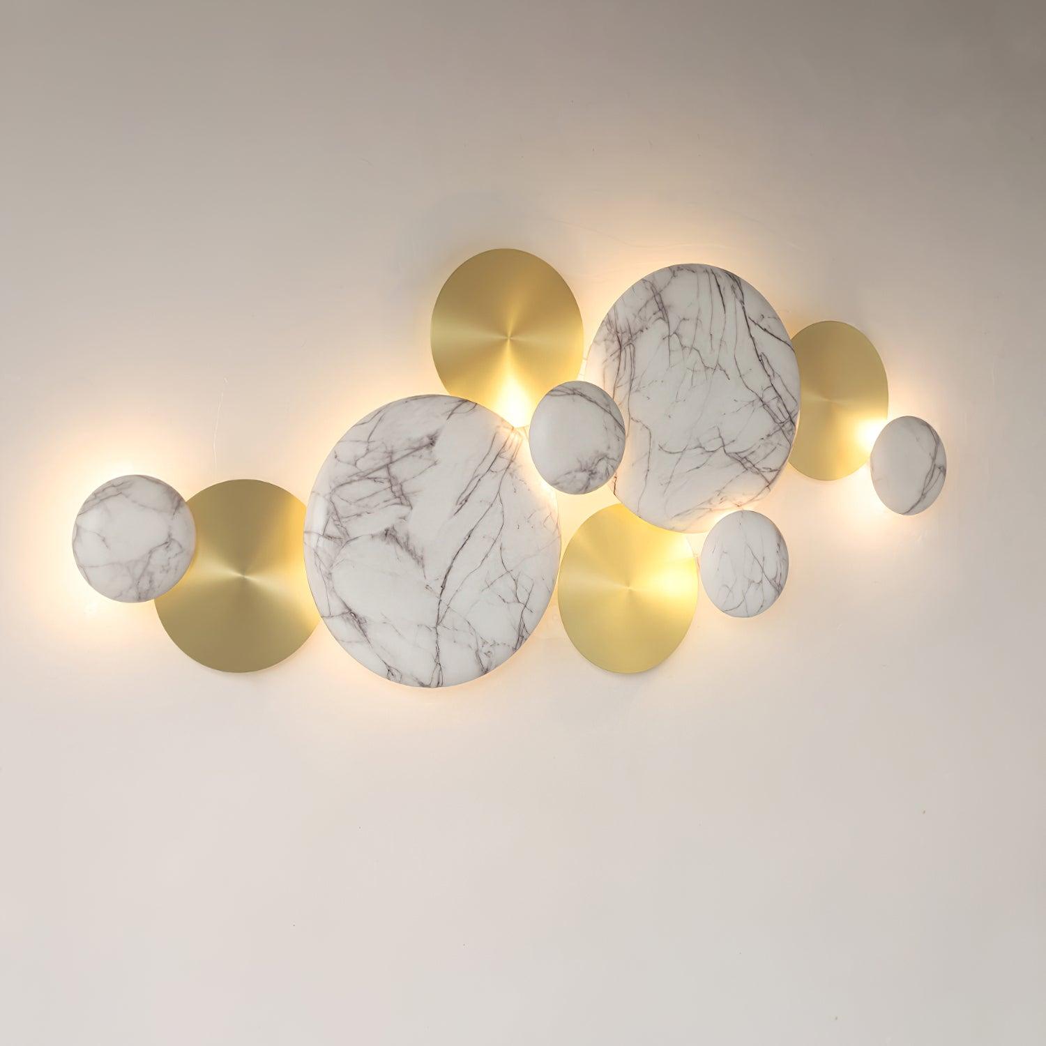 Wider angled view of the marbled-pattern Pisco lamp with light behind the white and gold-tone discs