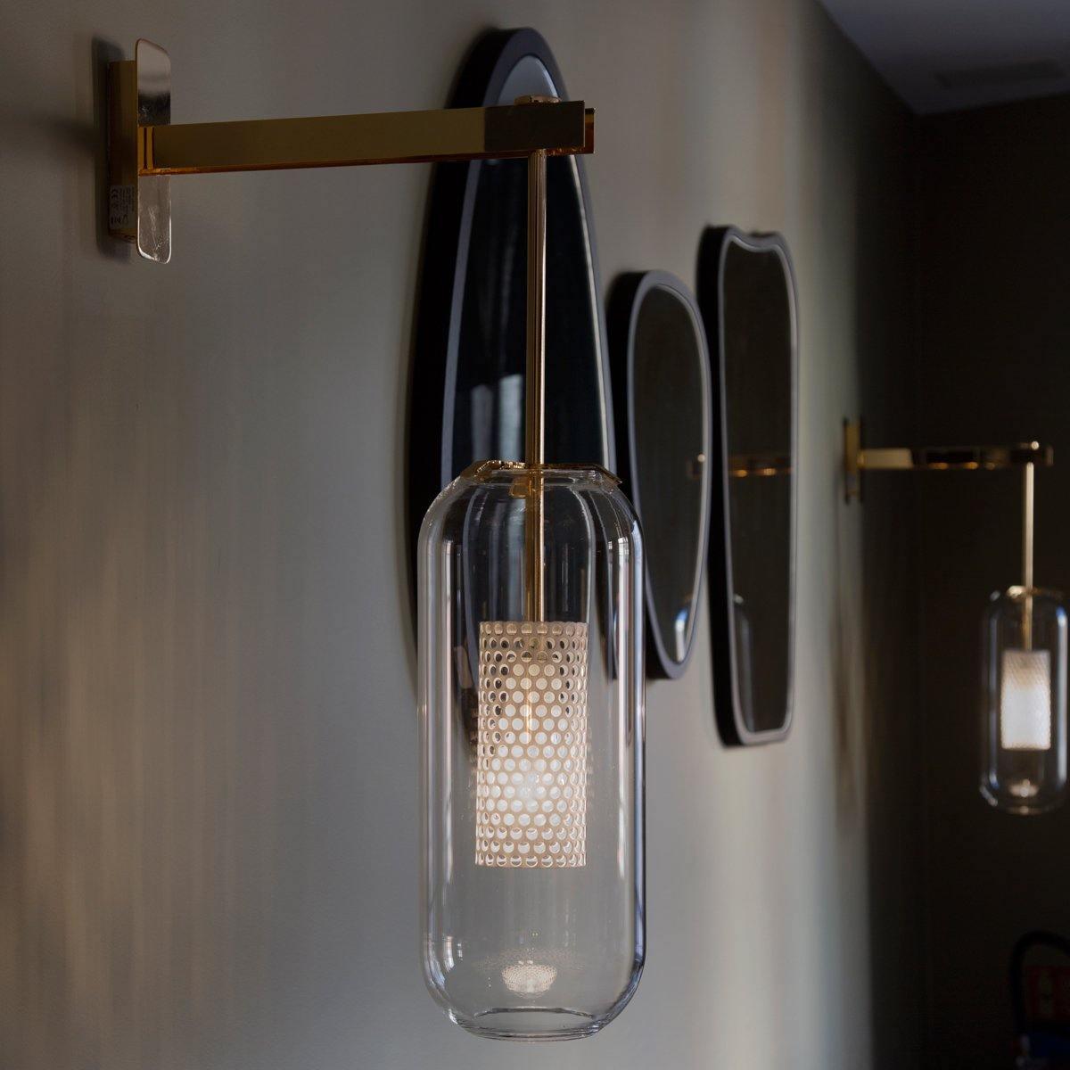 Suspended clear shade near dark-framed mirrors