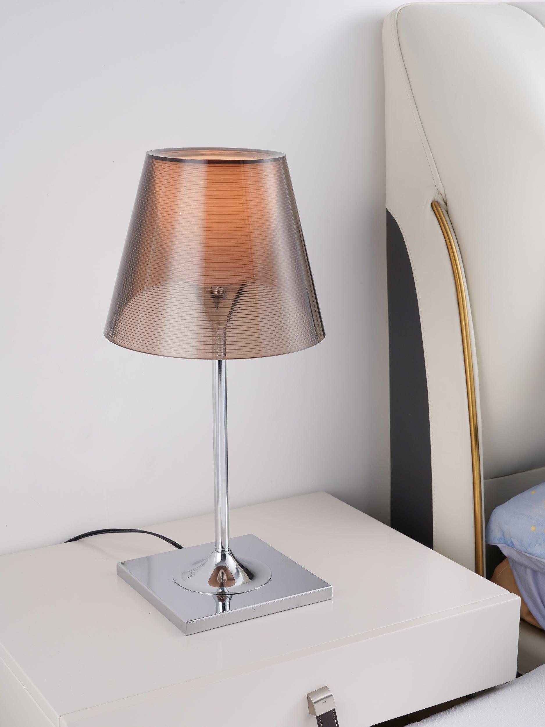 Unlit Bronze Chrome Prism lamp on a pale bedside cabinet