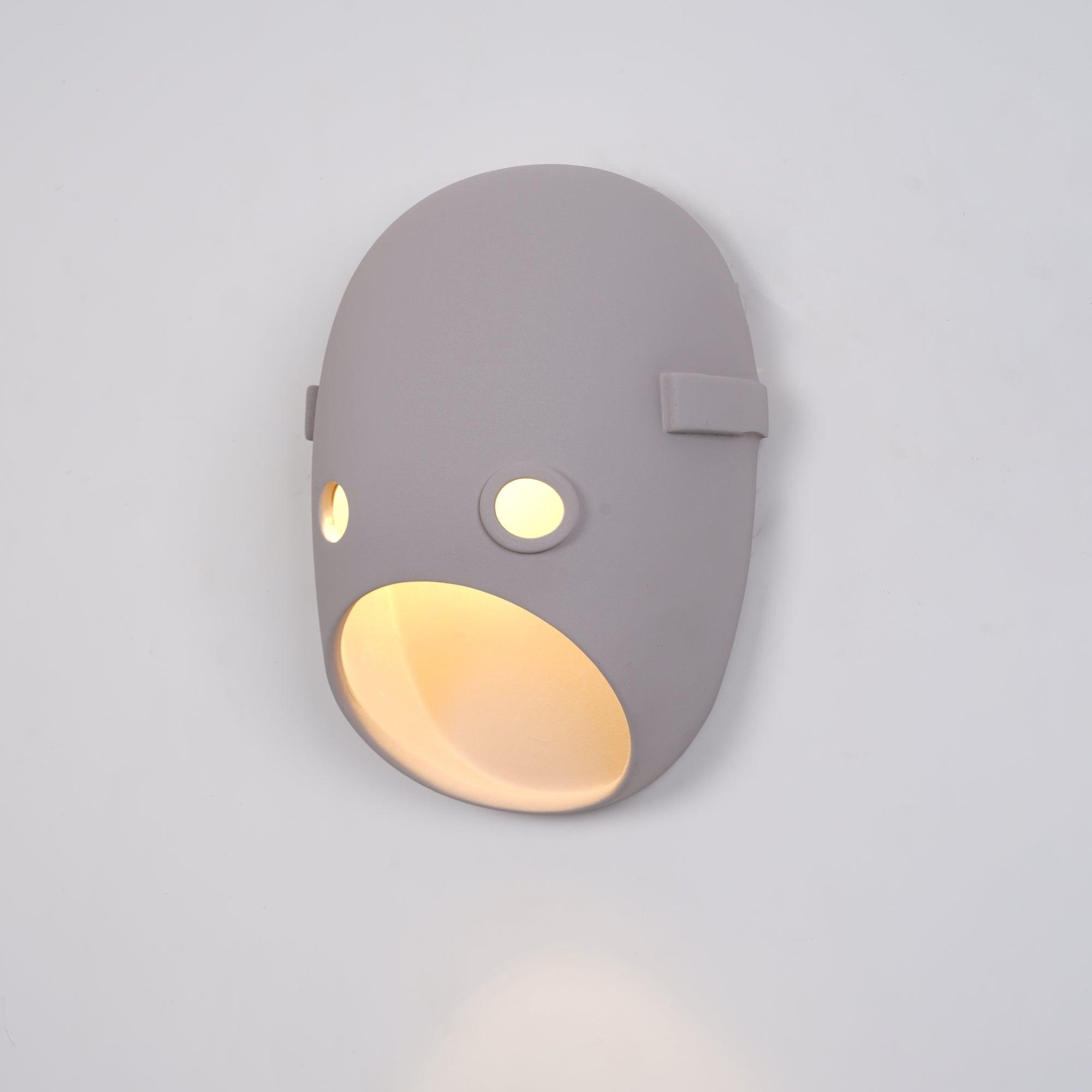 Angled view of an illuminated face wall light