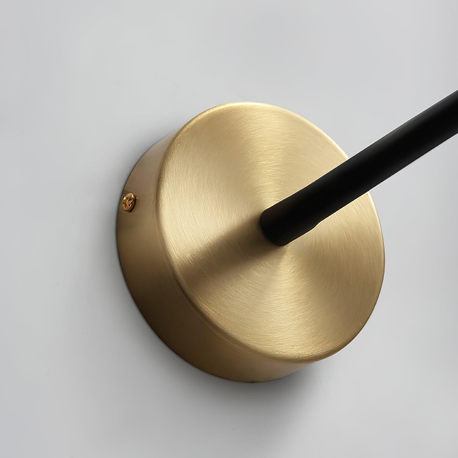 Detail of brushed gold round wall plate, black hose connection and visible side fixing screw