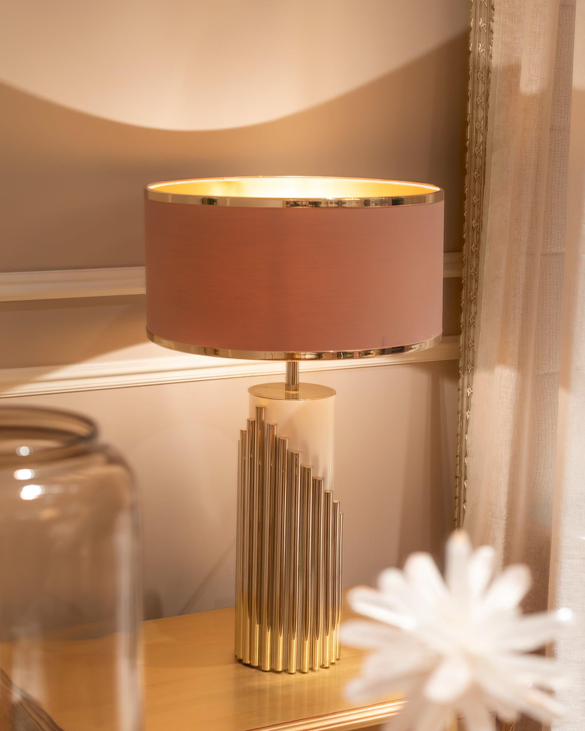 Illuminated Streamline lamp on a bedside table beside a glass vessel