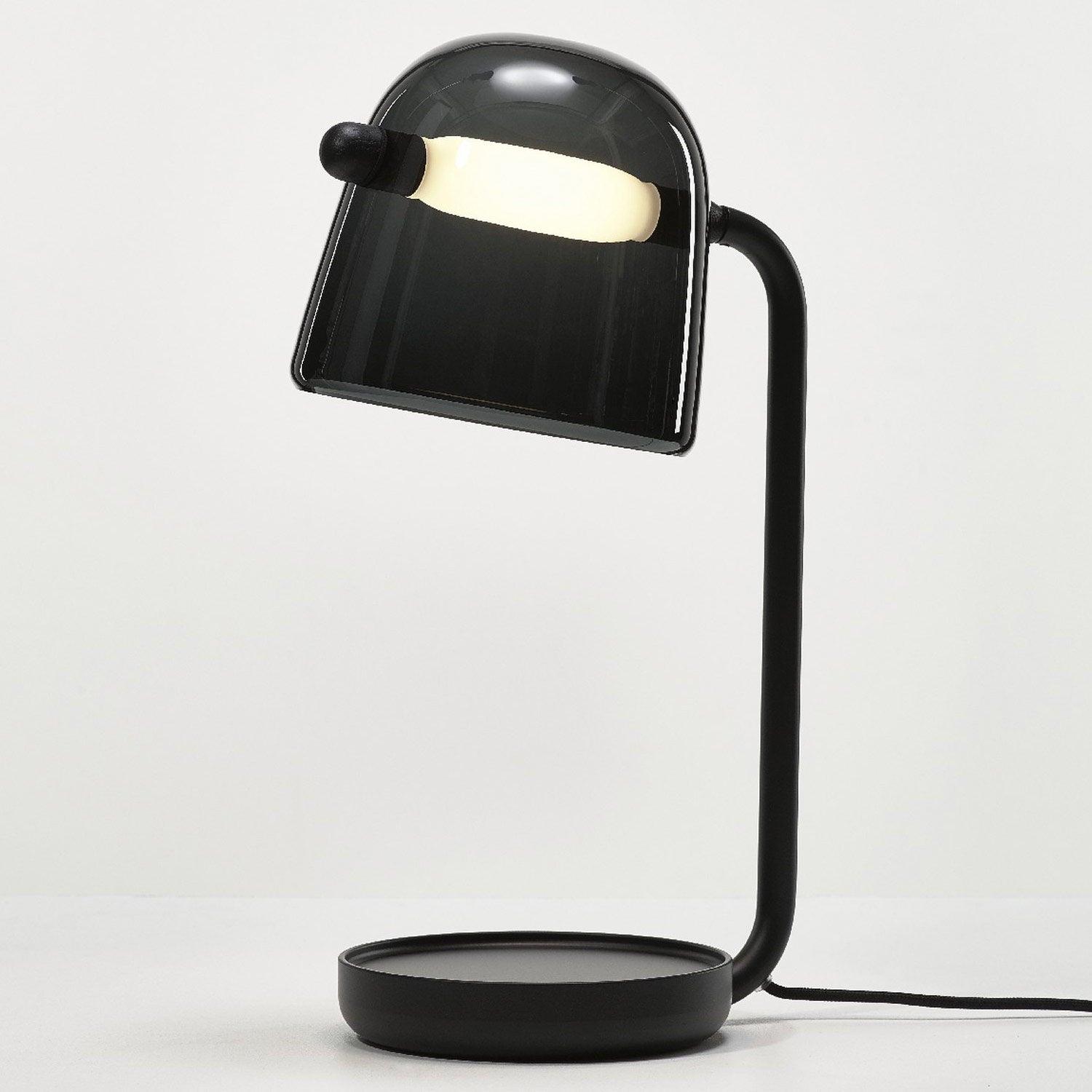 Black Mona table lamp with an illuminated tube crossing a dark glass shade