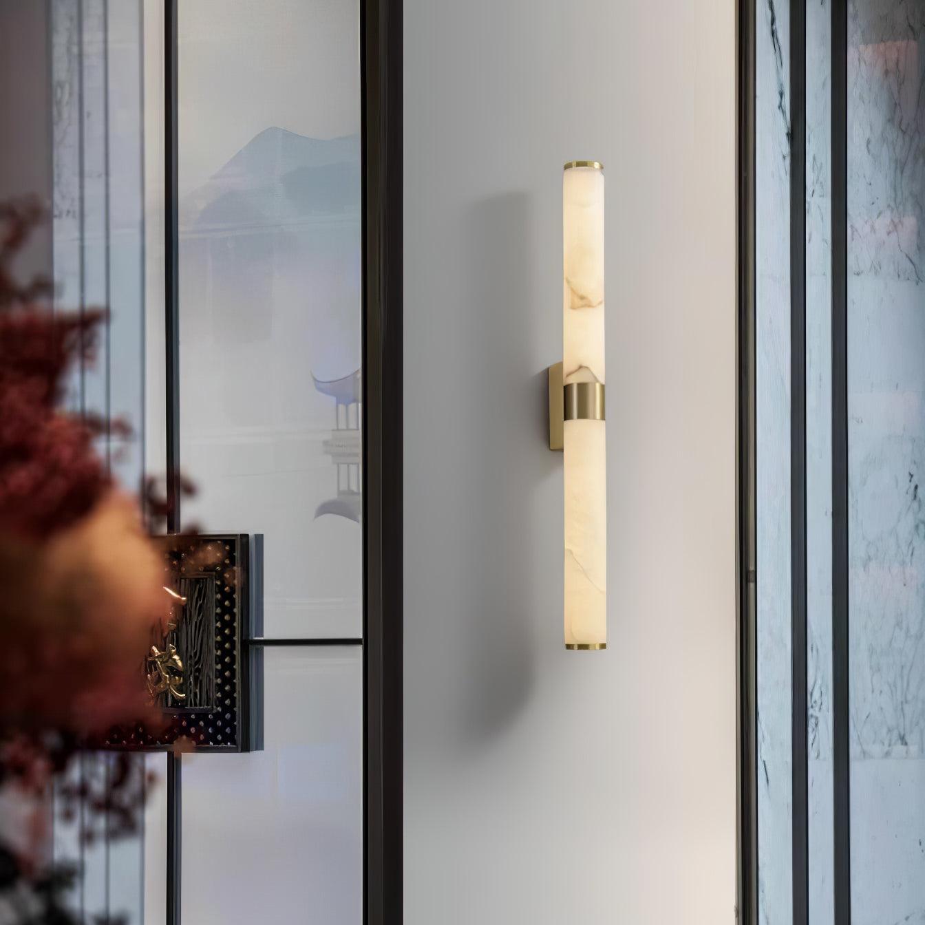 Vertical alabaster tube light beside a doorway