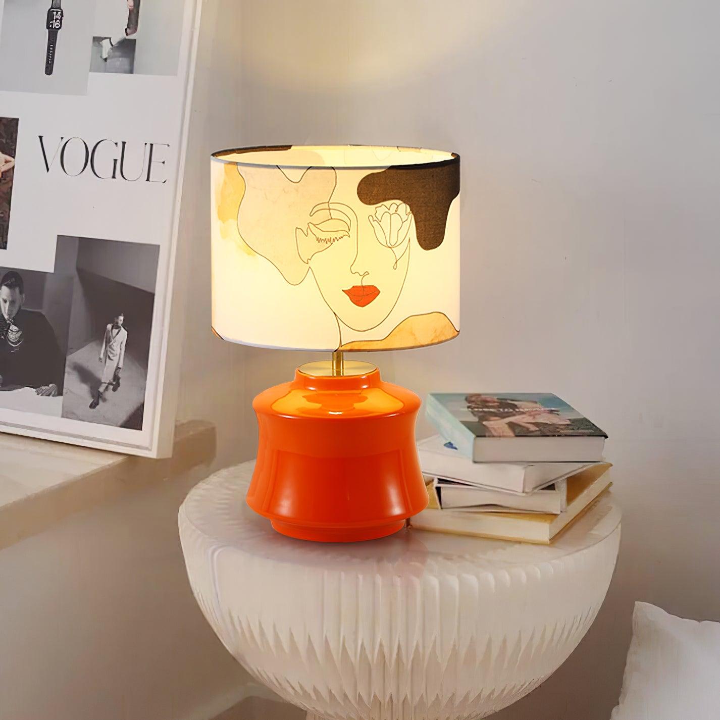 Marilyn Orange lamp on a white round table beside books