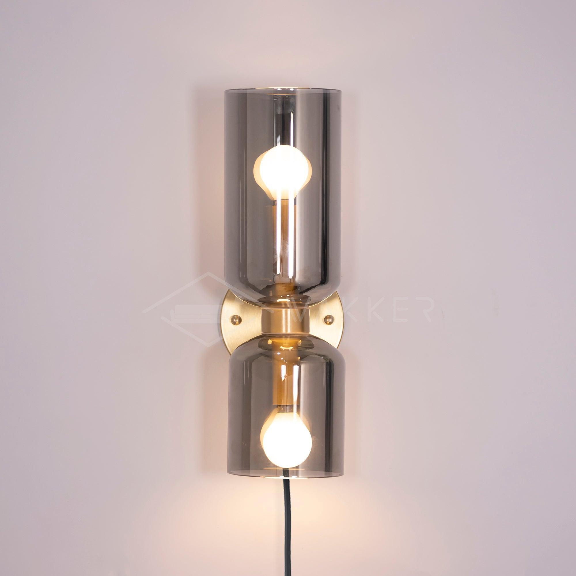 Satin Brass and Smoked Gray cylinders with lit bulbs