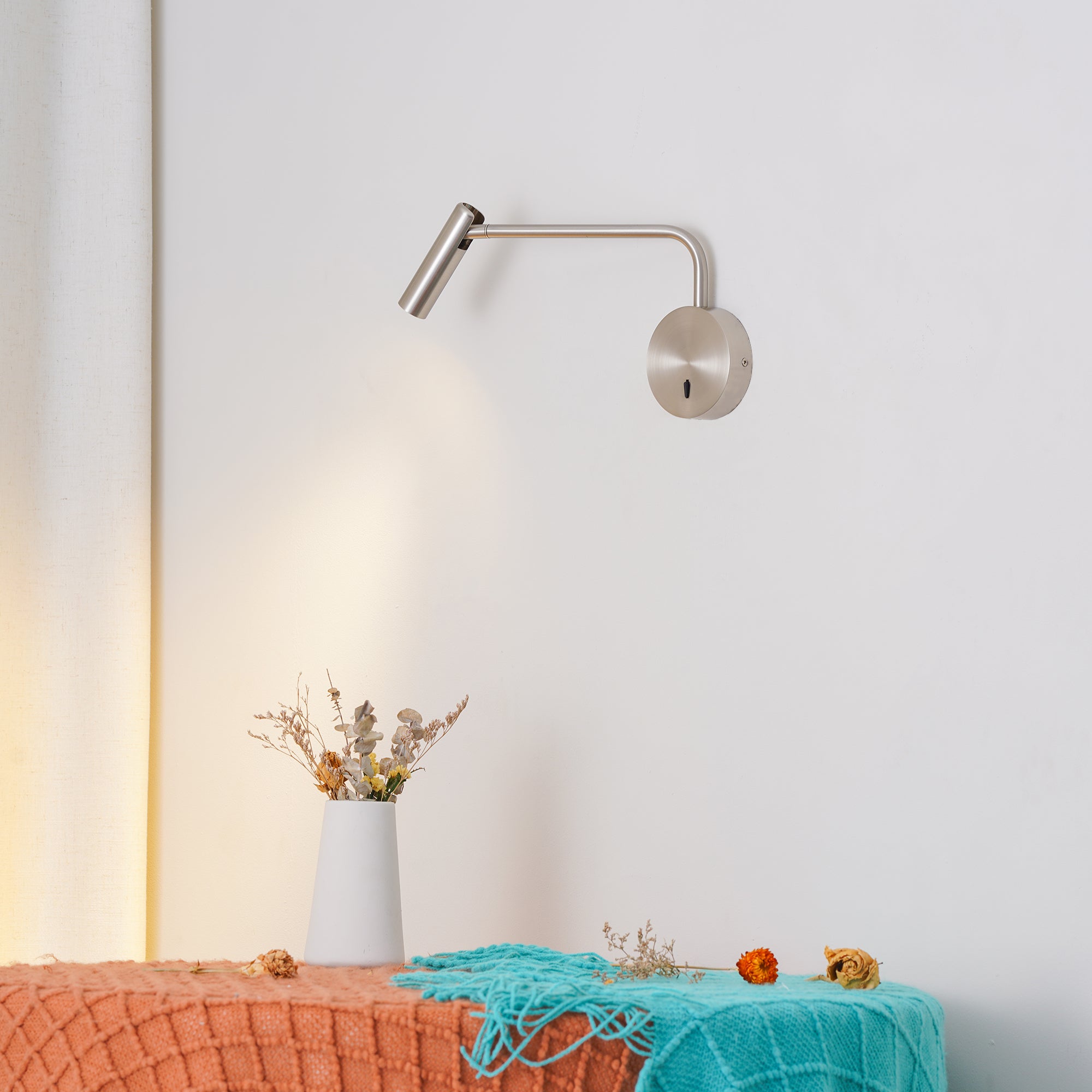 Angled metal reading light over a fabric-covered surface