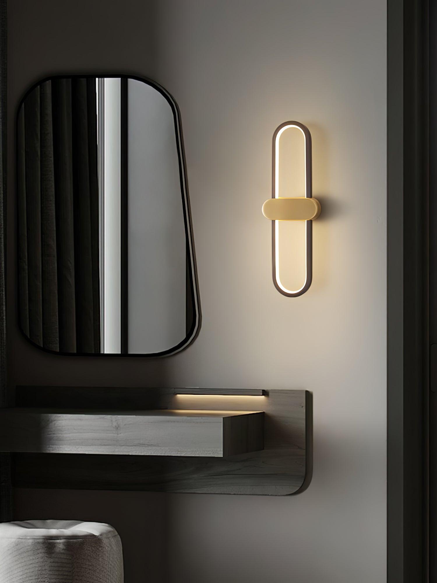 Closer black-loop and gold-centre wall light beside a mirror above a dresser
