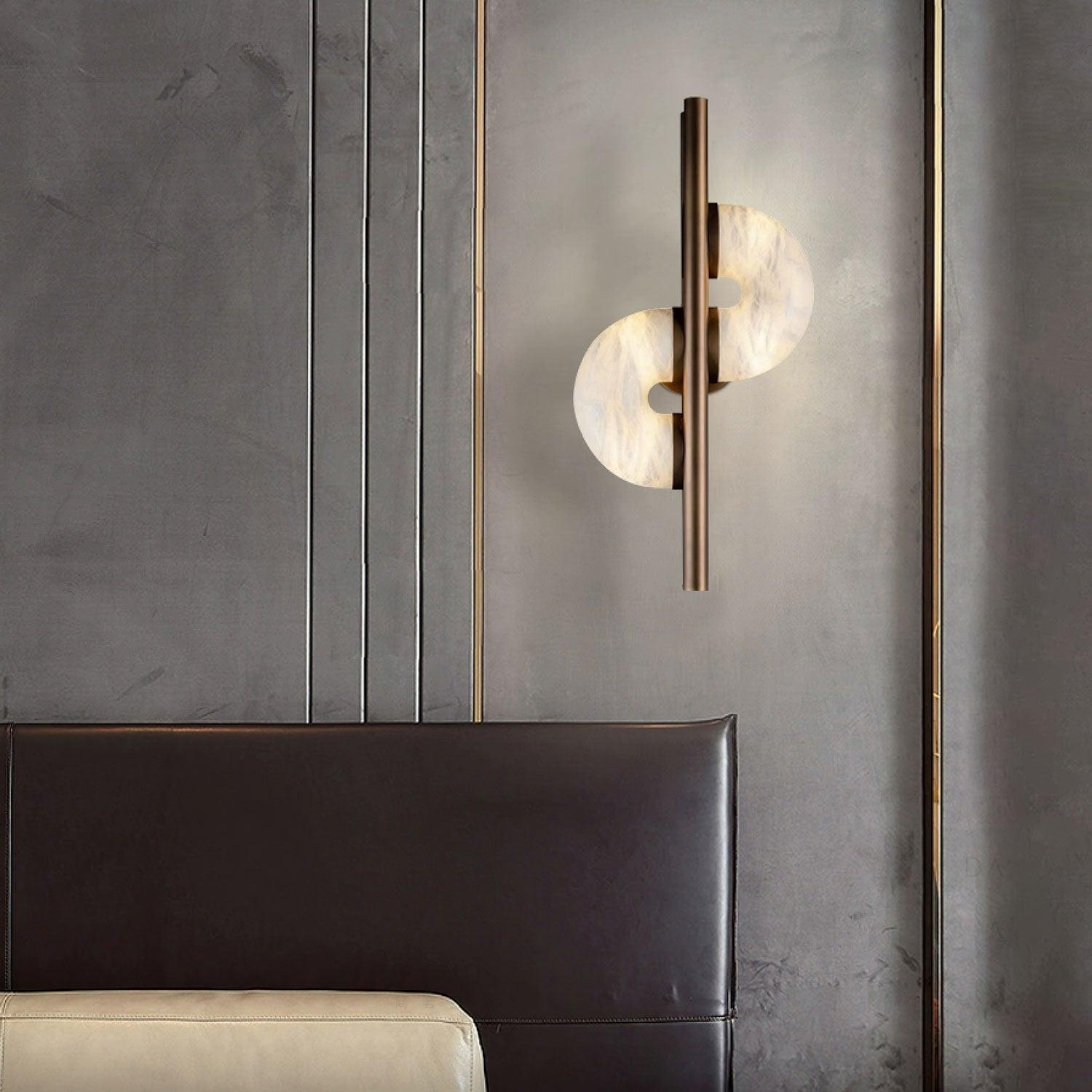Lit Dolly above dark leather headboard and cream bedding, with gold vertical trim on the grey bedroom wall