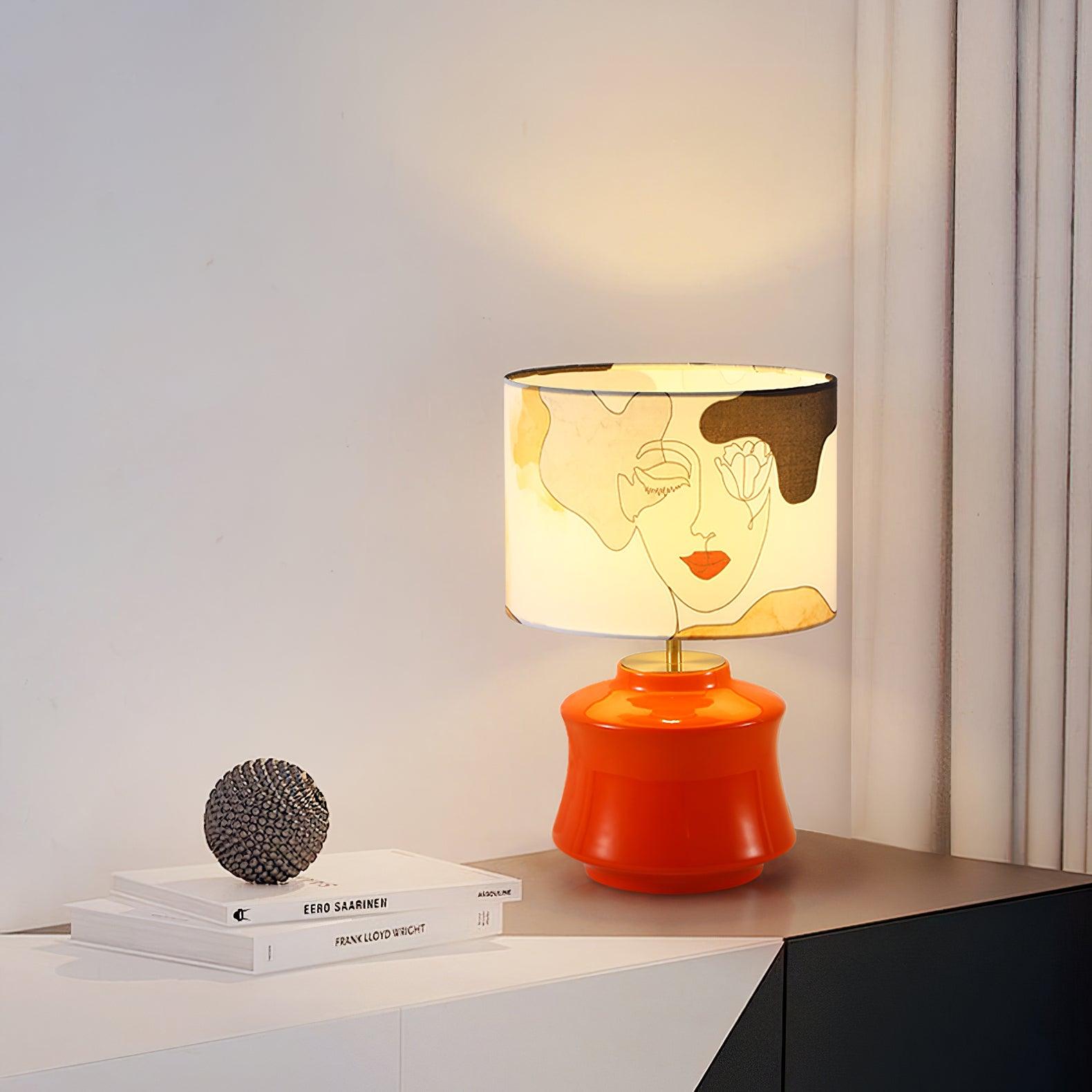 Marilyn Orange lamp on a white table beside a book