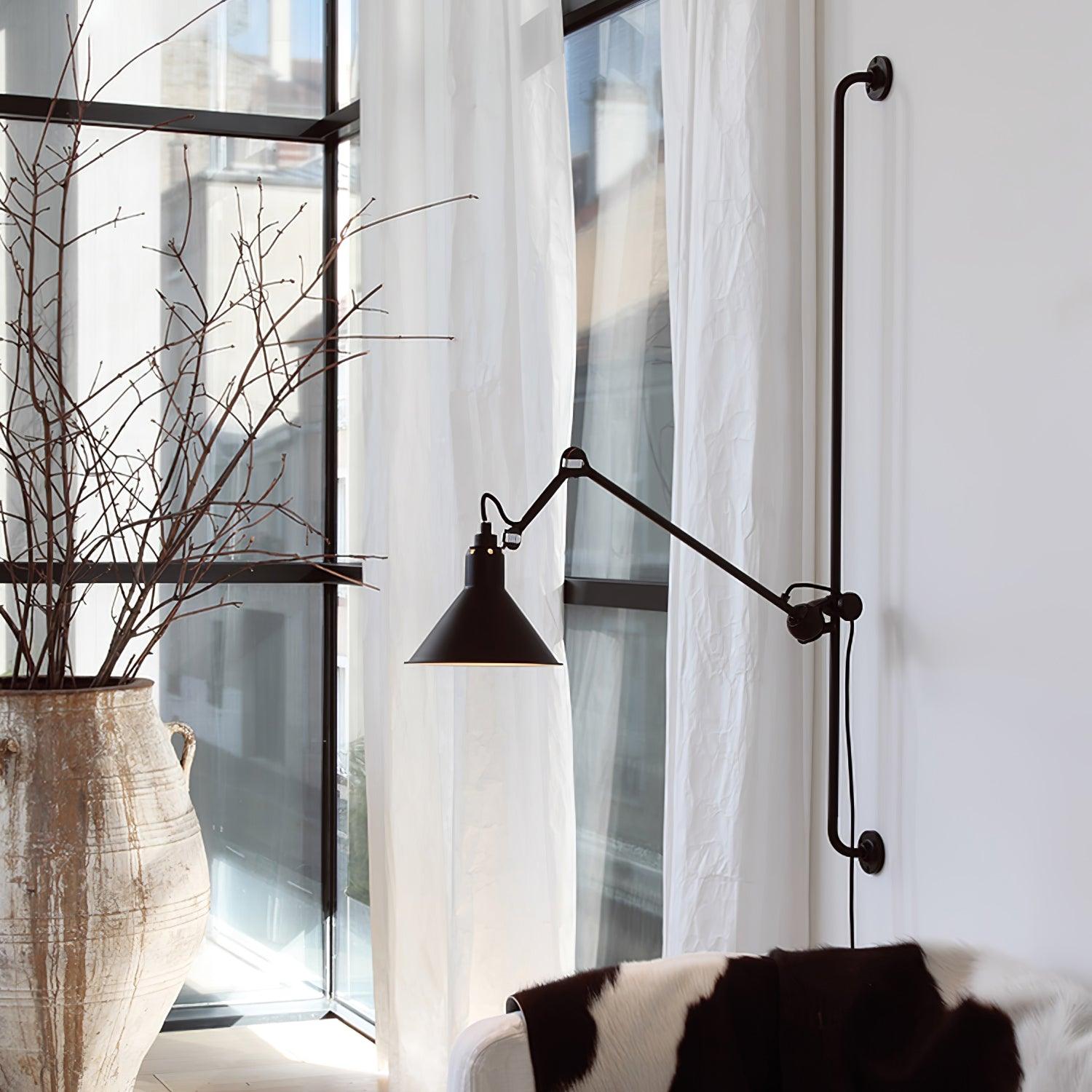 Dark conical wall light beside a window