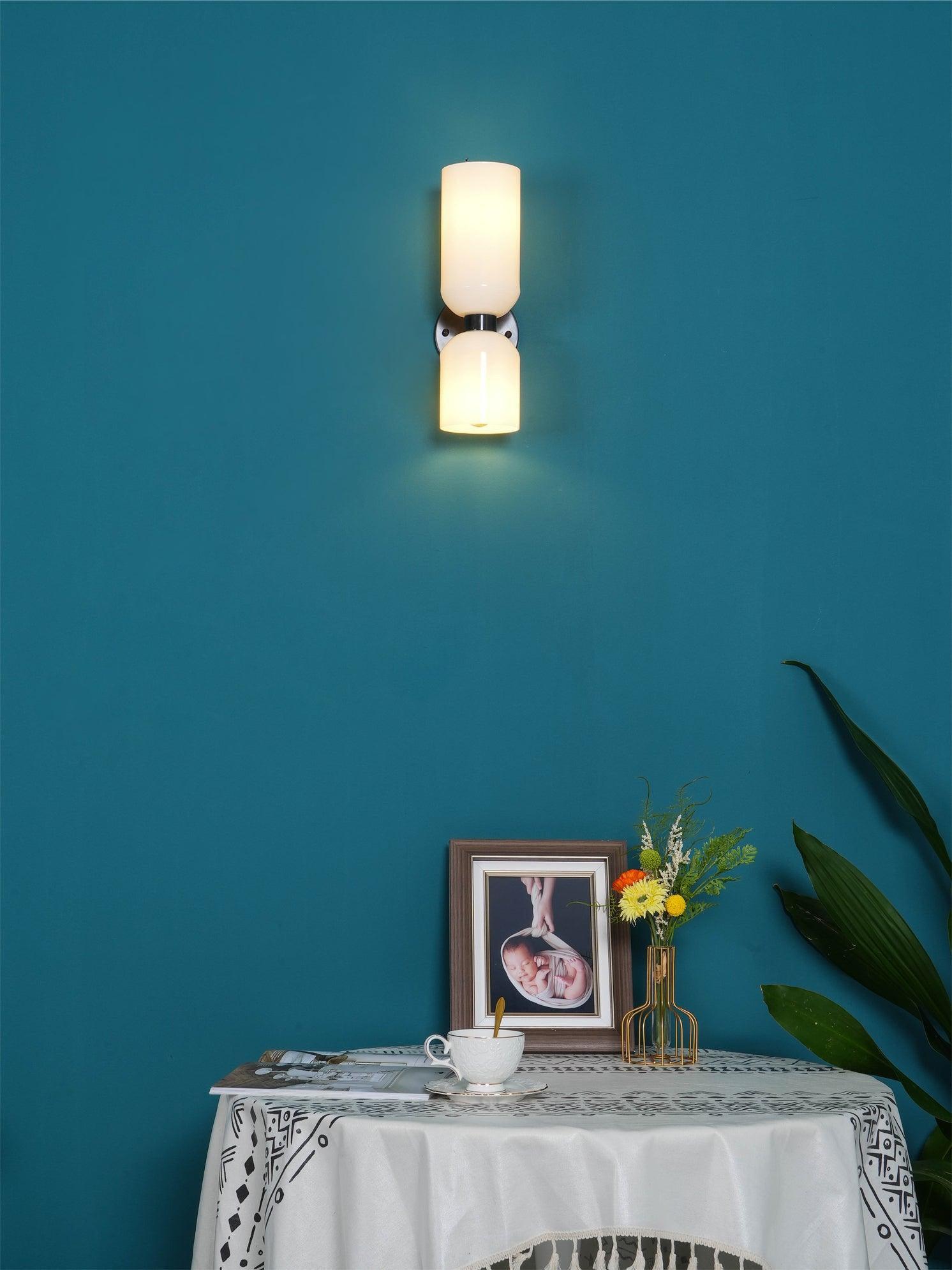 Opal cylinder wall lamp above a side table