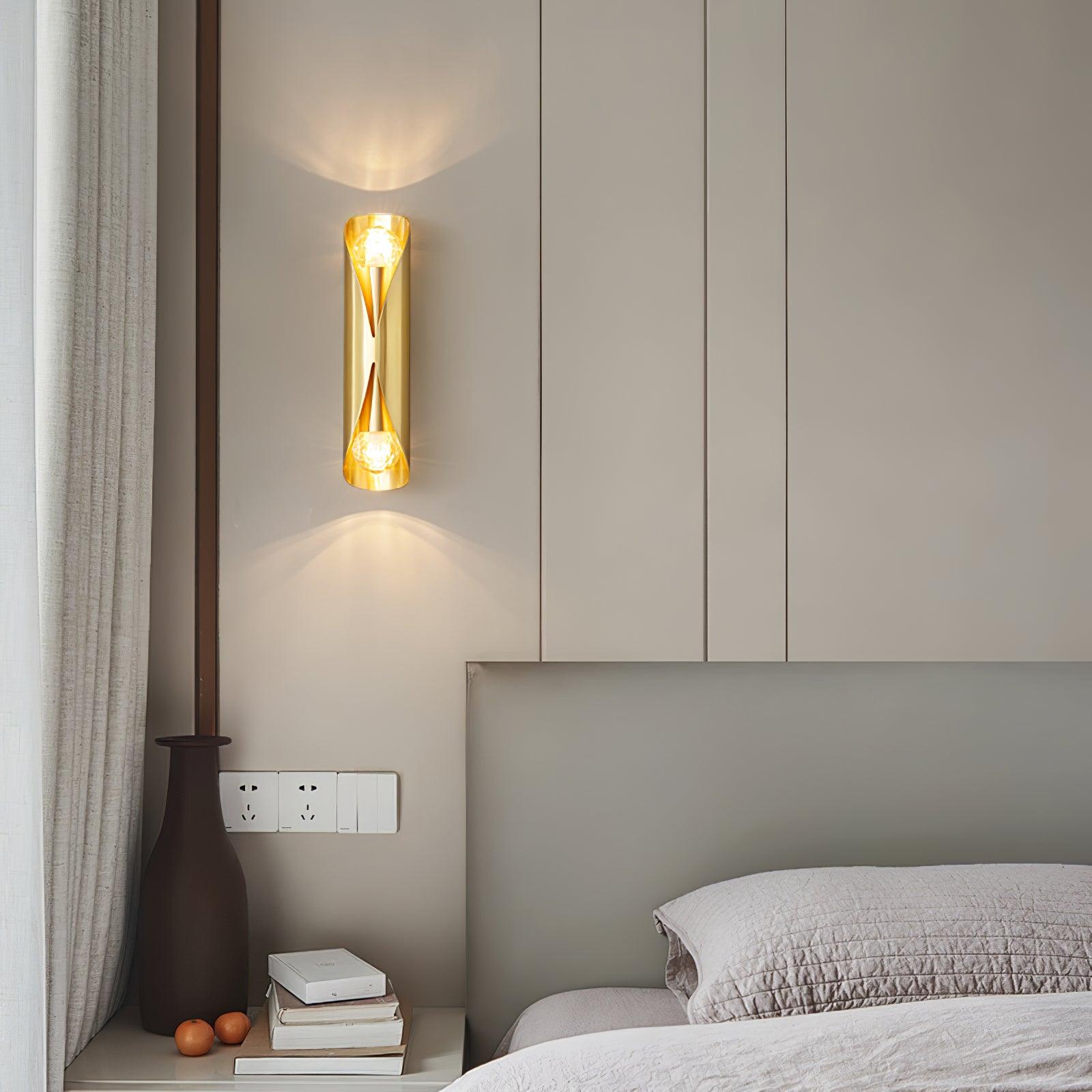 Brass wall light above a bedside table