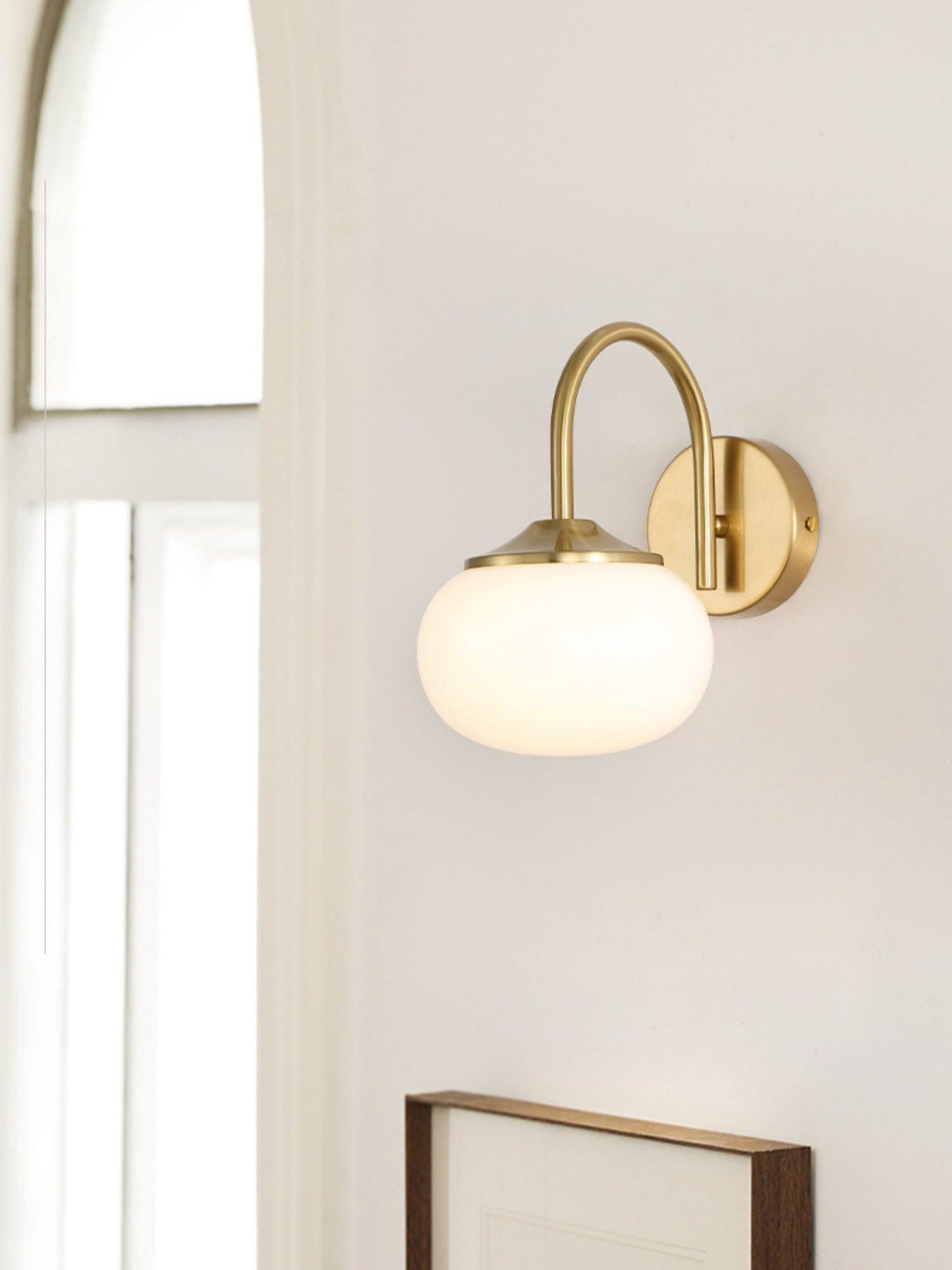 Pale rounded wall shade beside a tall window