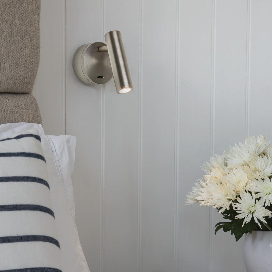 Silvery reading lamp beside a bed