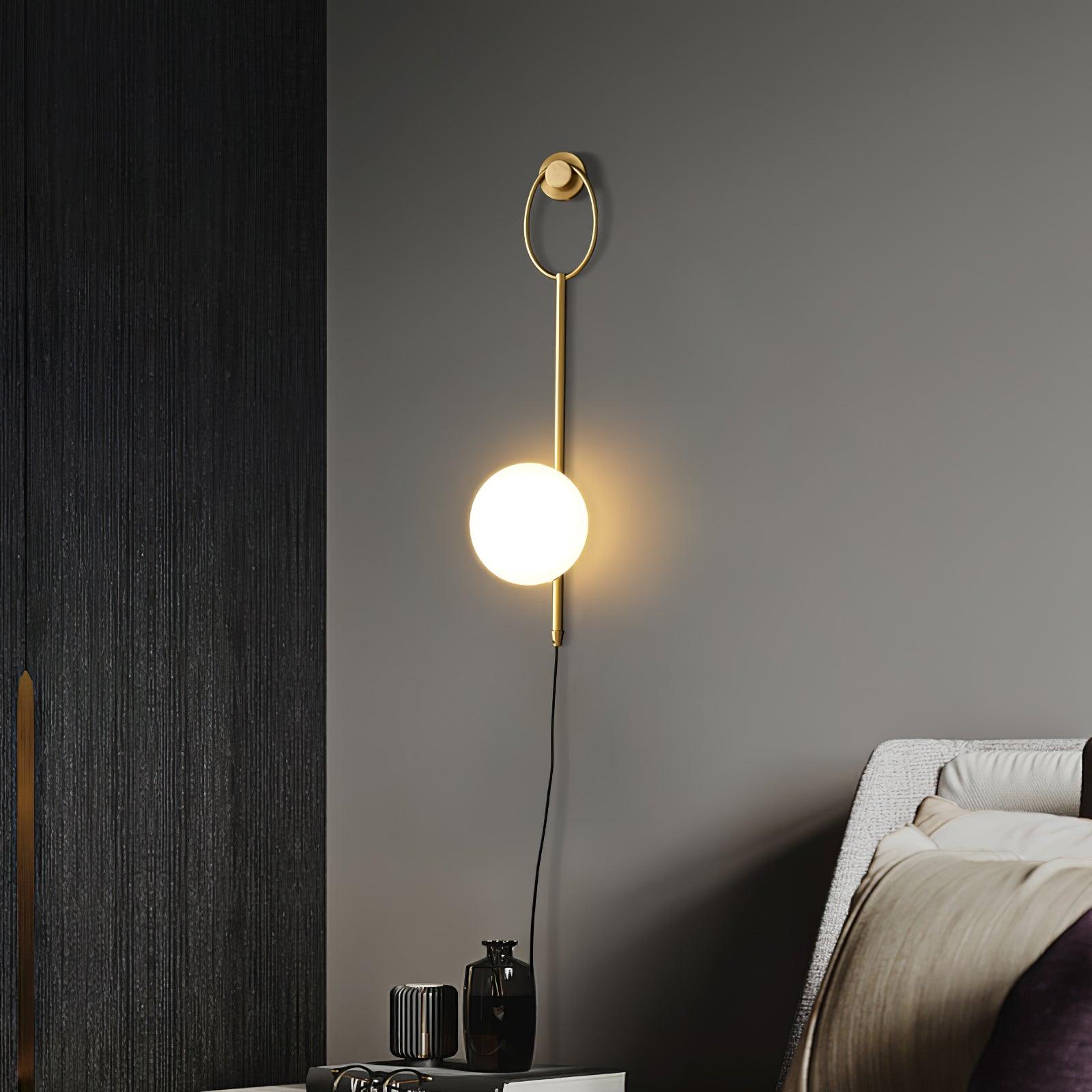 Ballon wall lamp with trailing cord on a dark wall