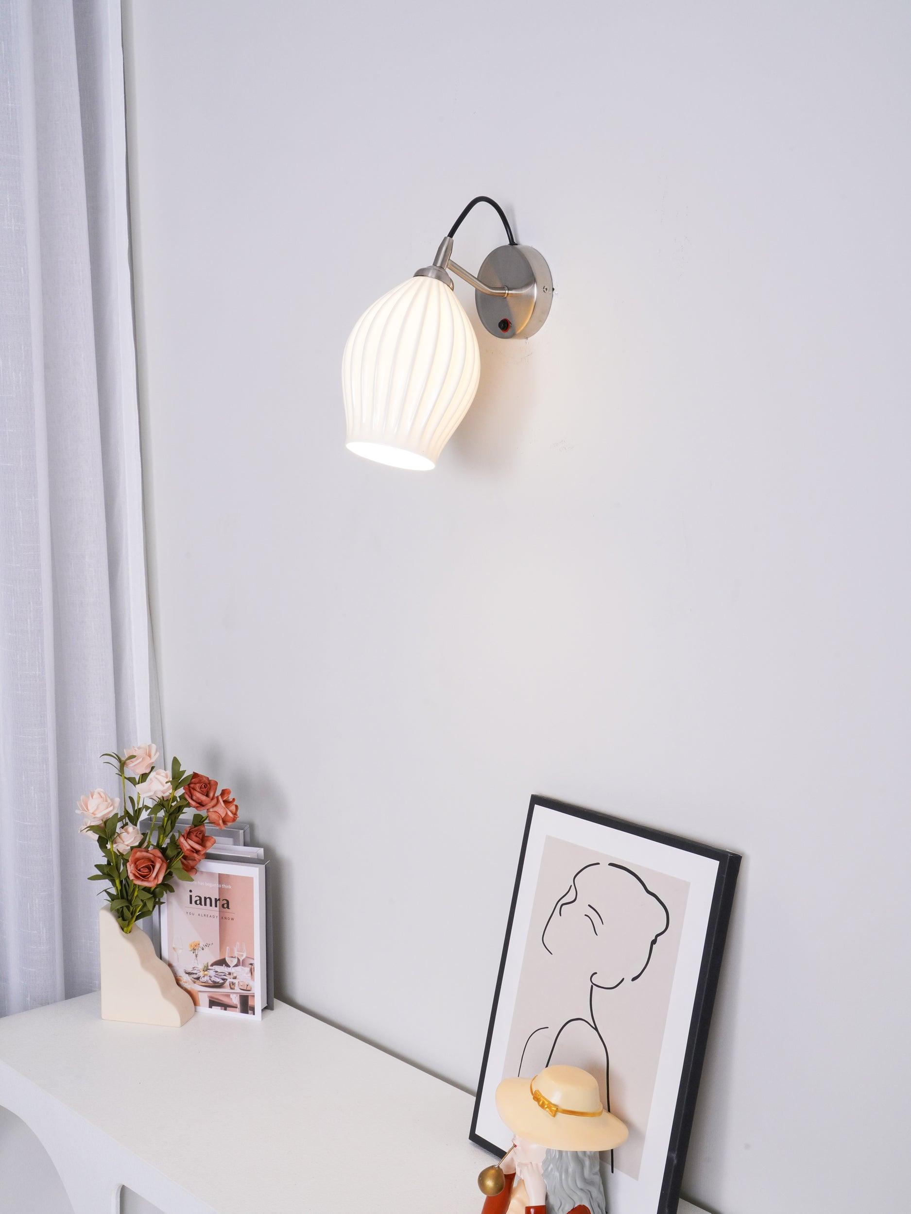 Lit ribbed wall shade beside curtains and flowers