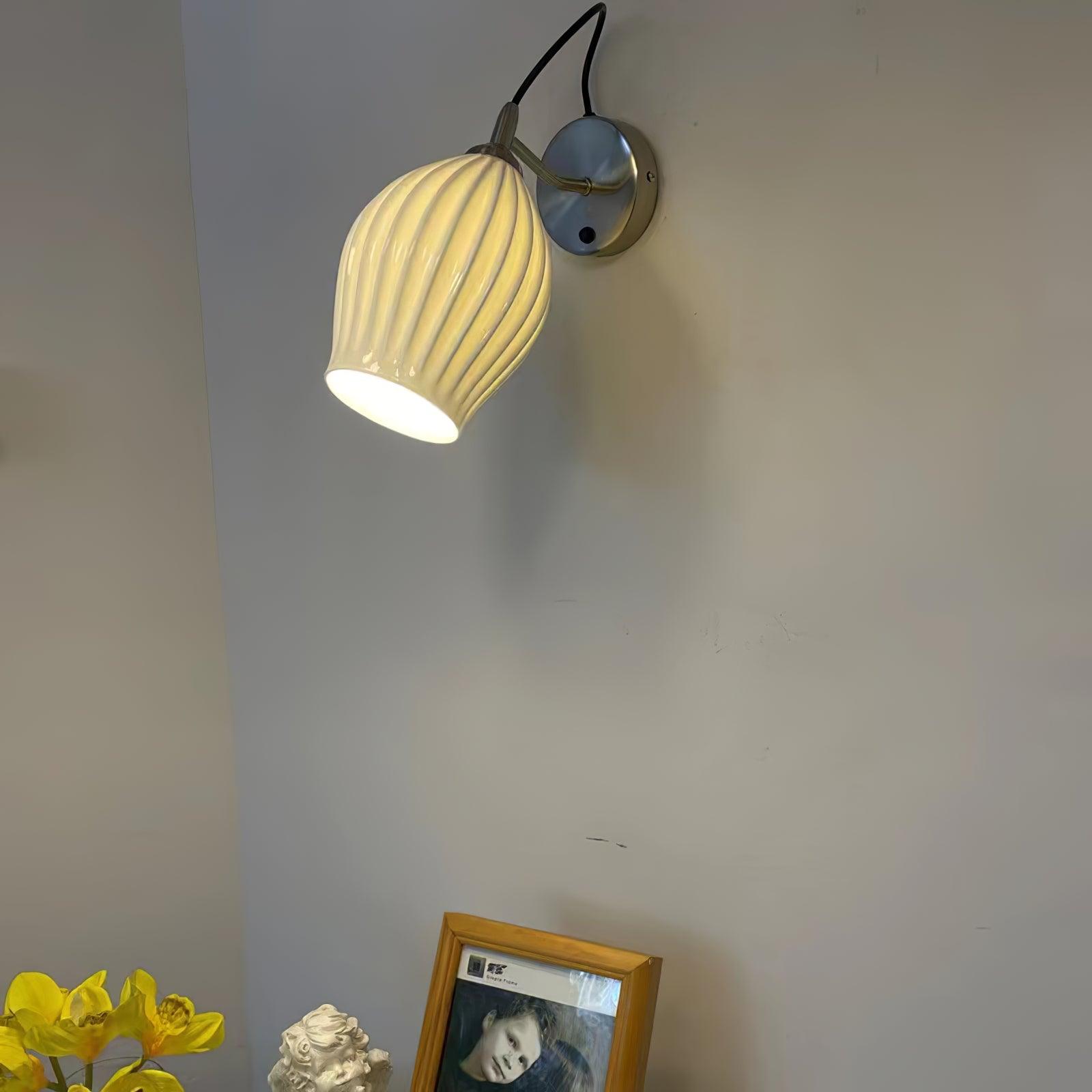 Warm-lit ceramic shade above flowers and a framed photograph