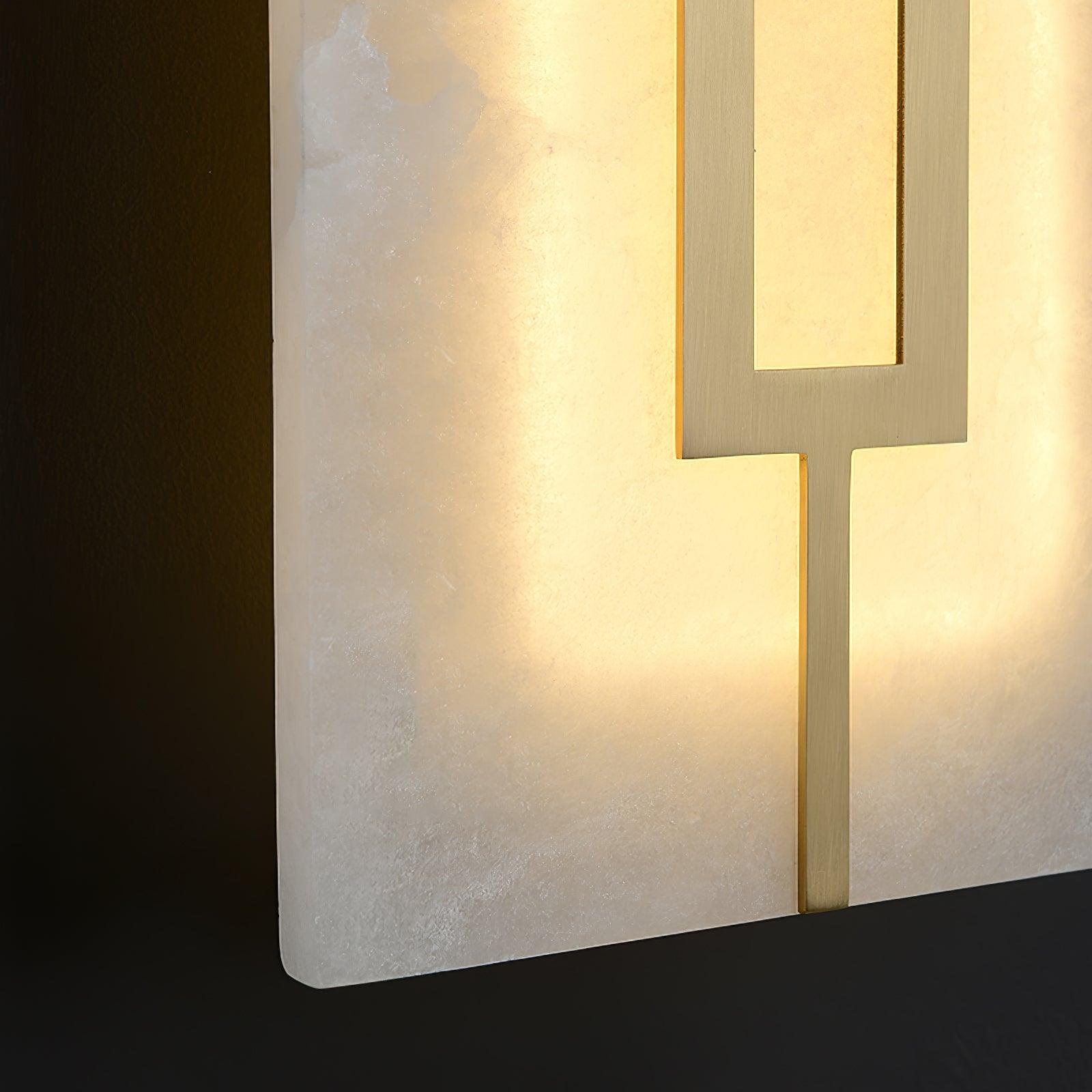 Close lower edge of glowing white textured panel and brushed brass-tone strip with rounded stone-look corner