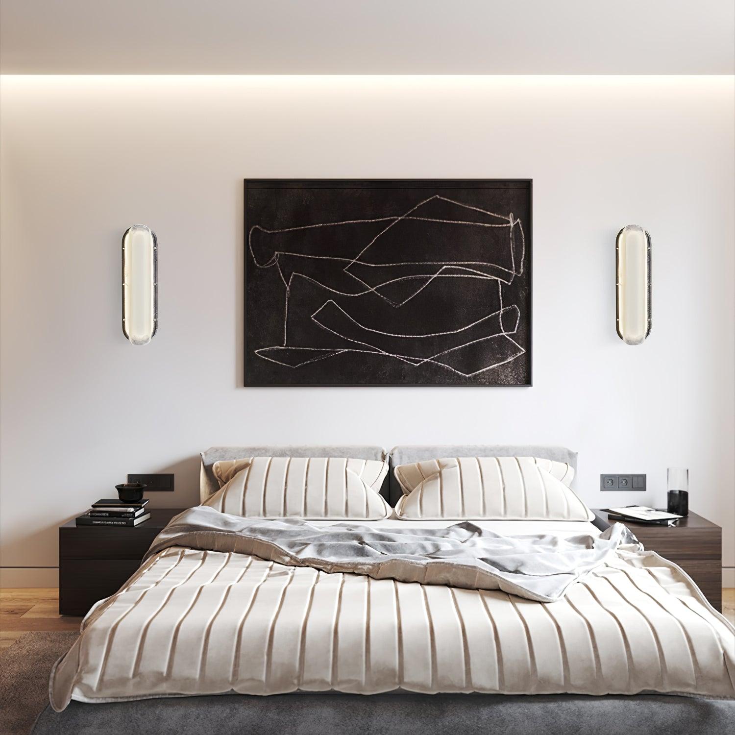 Pair of rounded glass wall lights flanking framed artwork above a bed and nightstands