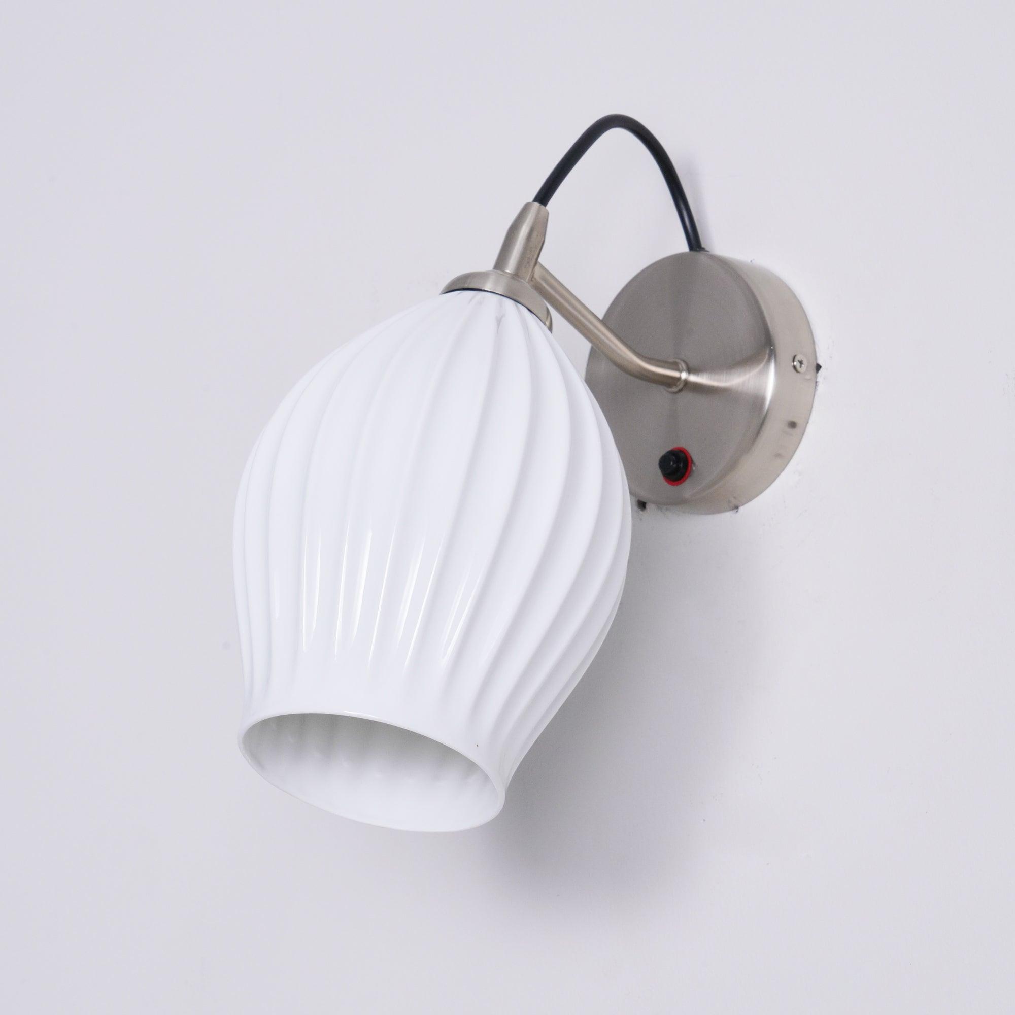 Unlit white ceramic wall shade with visible cord loop