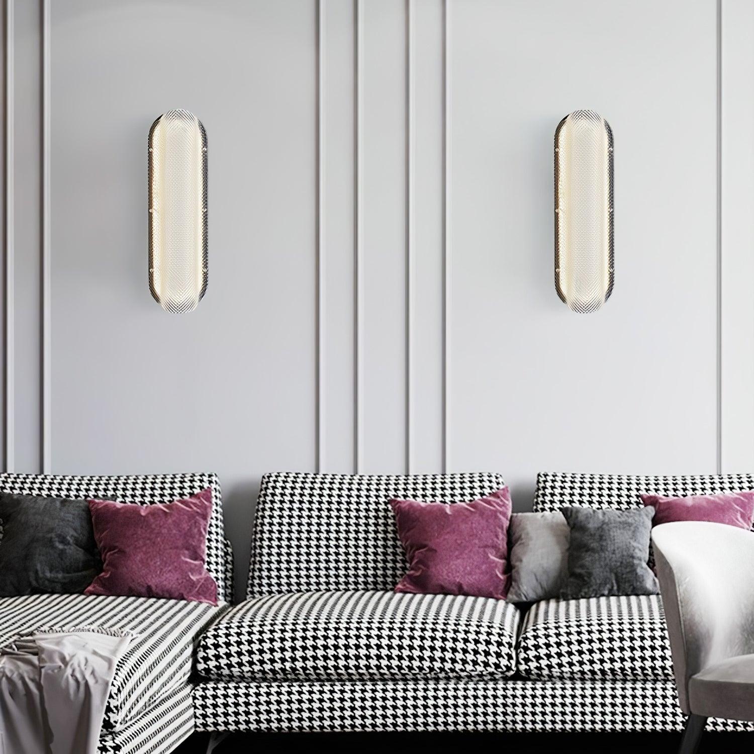 Two lit vertical textured glass wall lights above houndstooth seating with purple and grey cushions