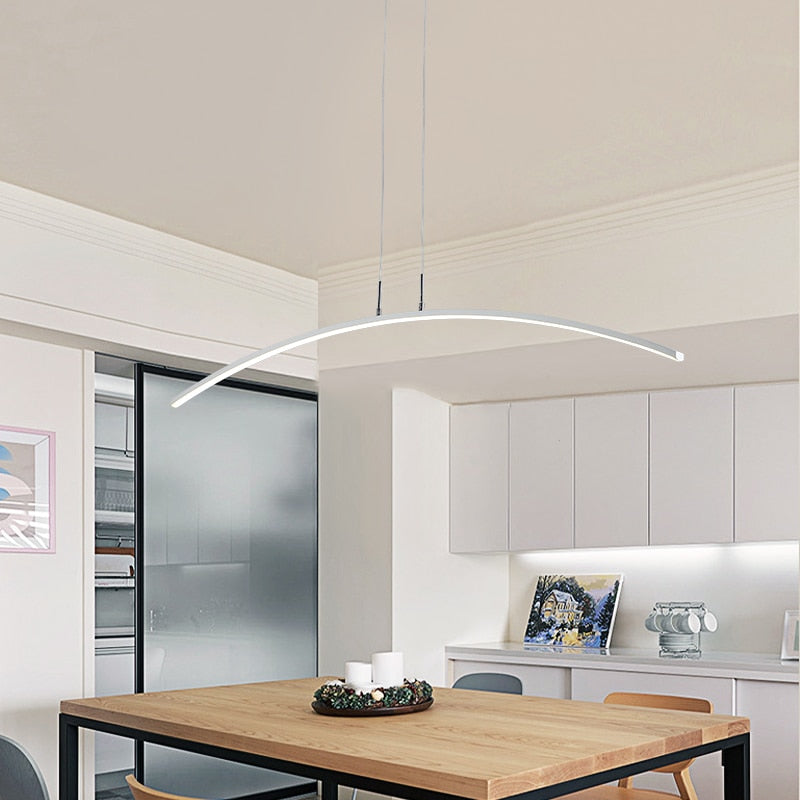White Edge arched pendant above a wood table in a bright dining room.