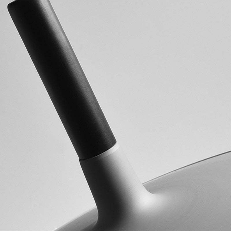Close black cylindrical sleeve joining the tapered pale neck and circular pendant shade