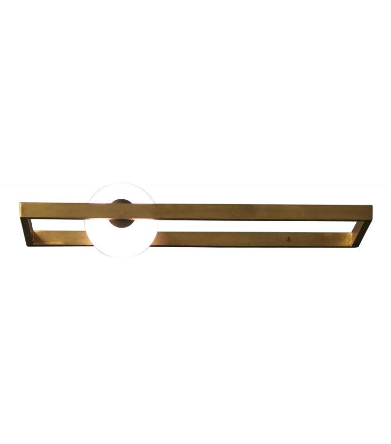 Gold-finish rectangular wall light with an illuminated globe offset to one side