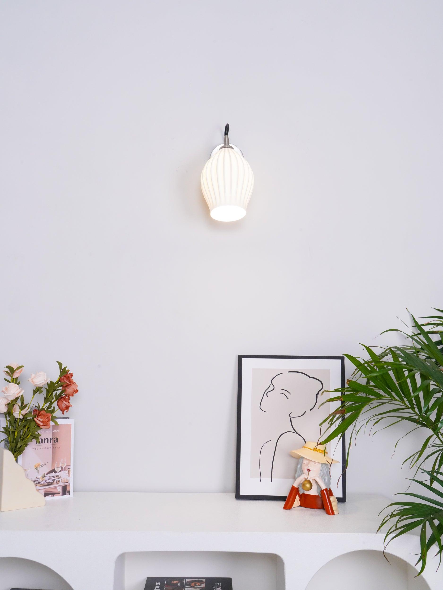 Small ceramic wall light above a console arrangement