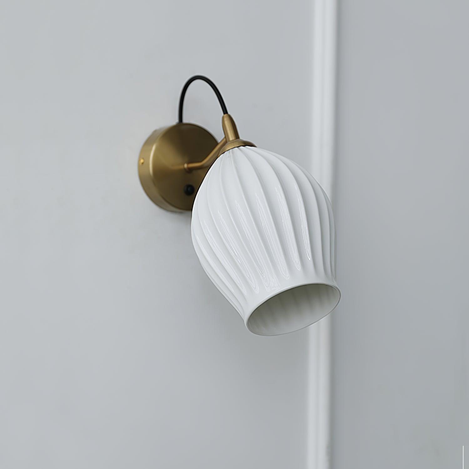 Unlit white ribbed shade angled from a metal wall plate