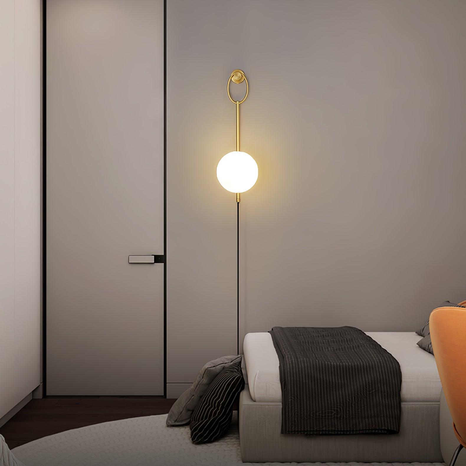 Glowing globe wall light beside a pale bedroom door