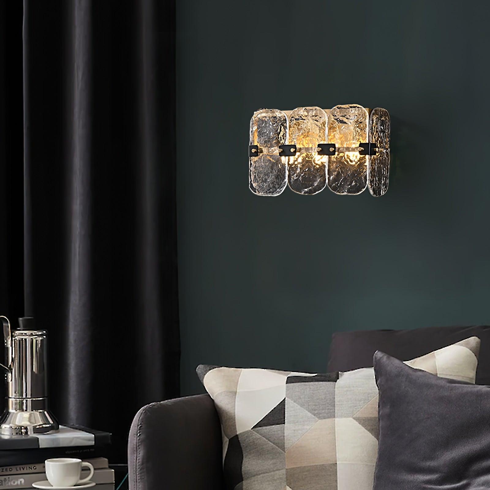 Clear glass wall sconce above an indoor sofa